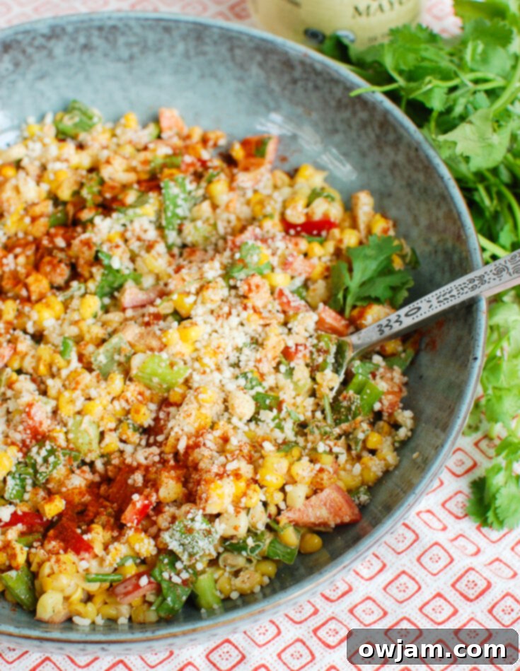23 Irresistible Sides to Elevate Your Taco Night 3 A colorful bowl of Mexican Street Corn Salad, featuring roasted corn kernels, cotija cheese, cilantro, and a creamy, zesty dressing.