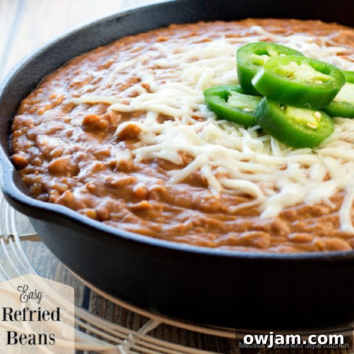 23 Irresistible Sides to Elevate Your Taco Night 13 A bowl of creamy, homemade Easy Refried Beans, garnished with a sprinkle of cheese and fresh cilantro, ready to be enjoyed.