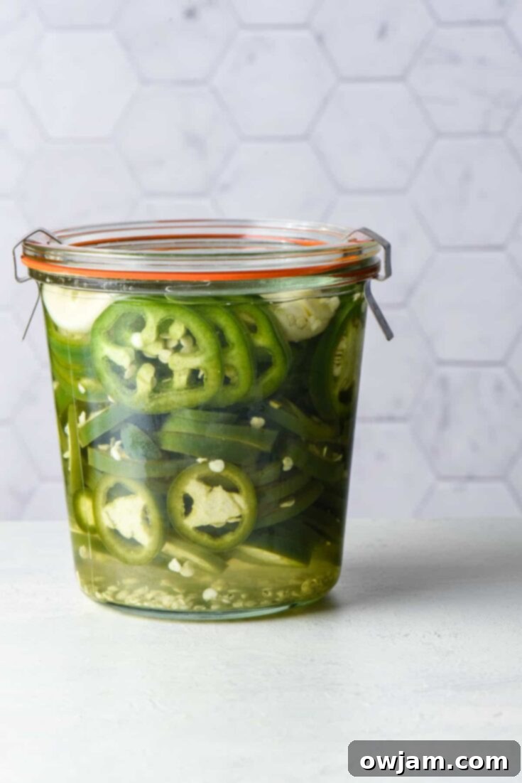 23 Irresistible Sides to Elevate Your Taco Night 19 Sliced Pickled Jalapenos in a glass jar, vibrant green and ready to add a spicy, tangy kick to any meal.