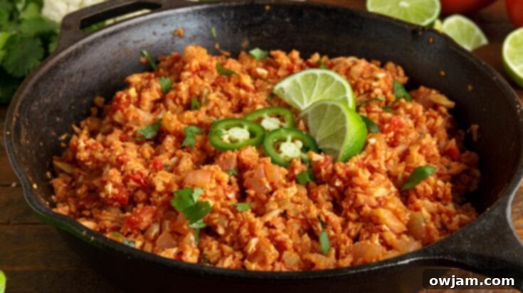 23 Irresistible Sides to Elevate Your Taco Night 8 A serving of Mexican Cauliflower Rice, a healthy and flavorful alternative to traditional rice, garnished with fresh cilantro and a lime wedge.