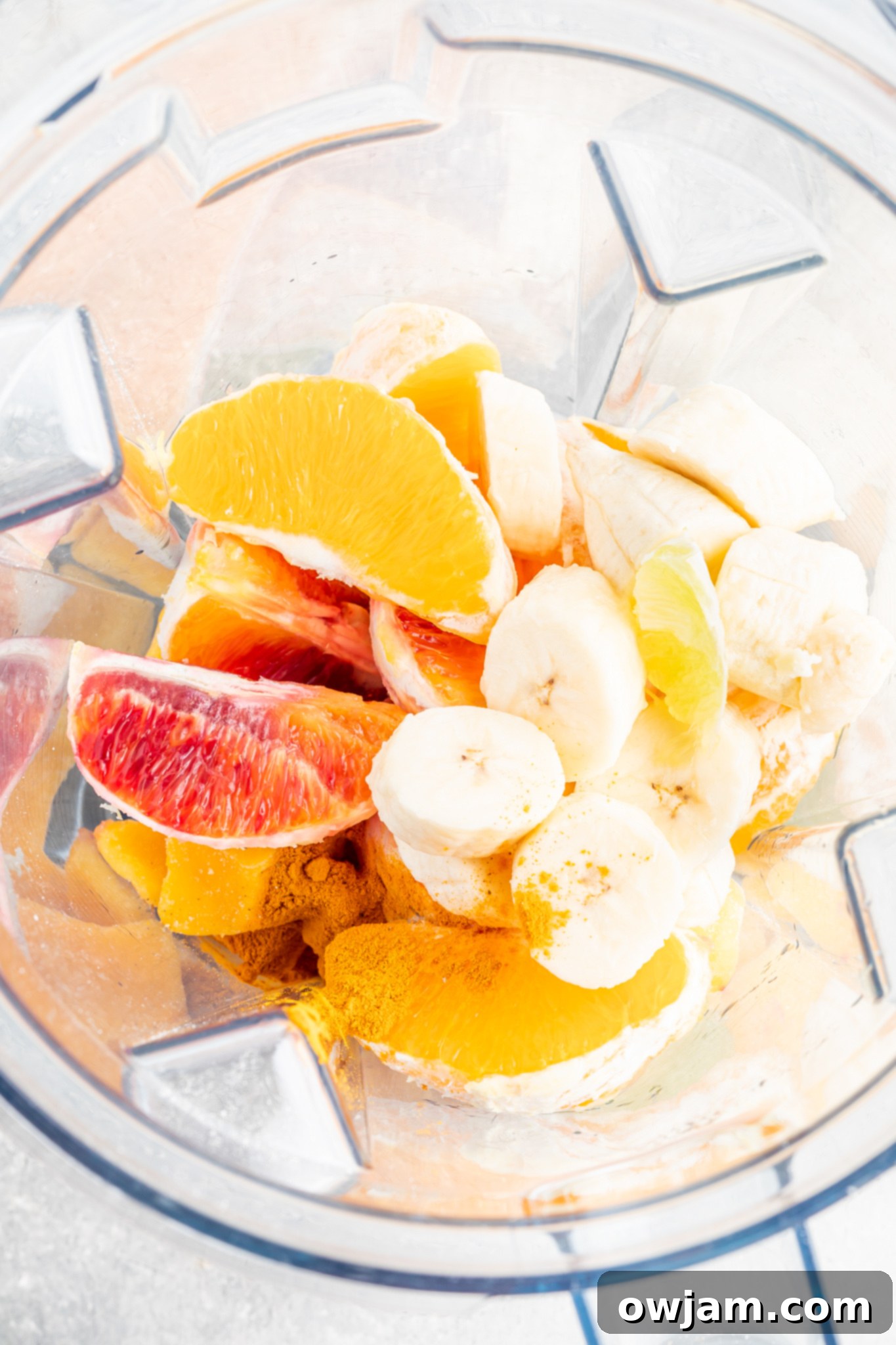 Ingredients for an Orange Smoothie being blended in a high-speed blender.