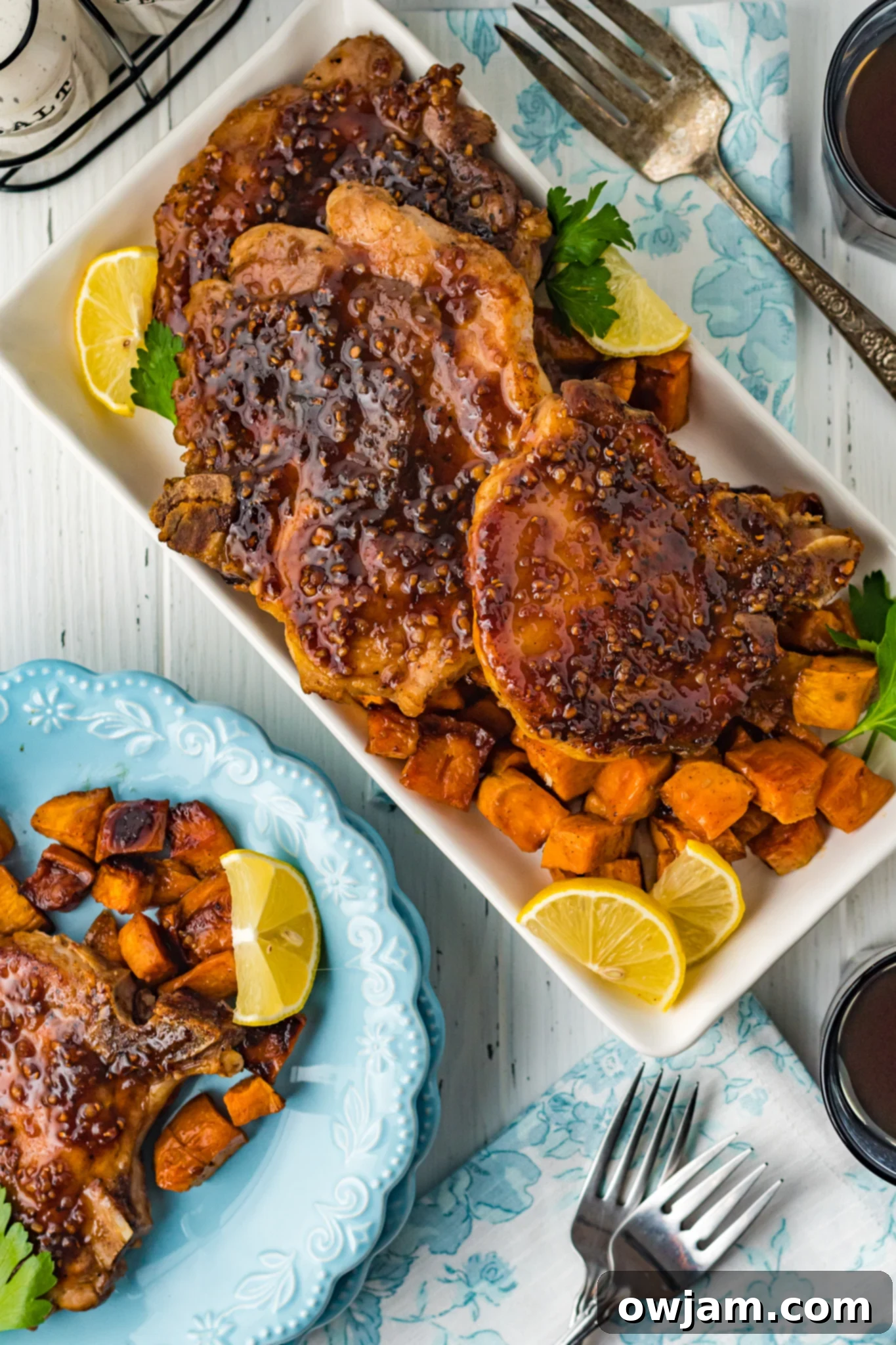 Maple Bourbon Glazed Pork Chops Recipe 12 Maple Bourbon Pork Chops Recipe on a platter, ready to serve with sweet potatoes.