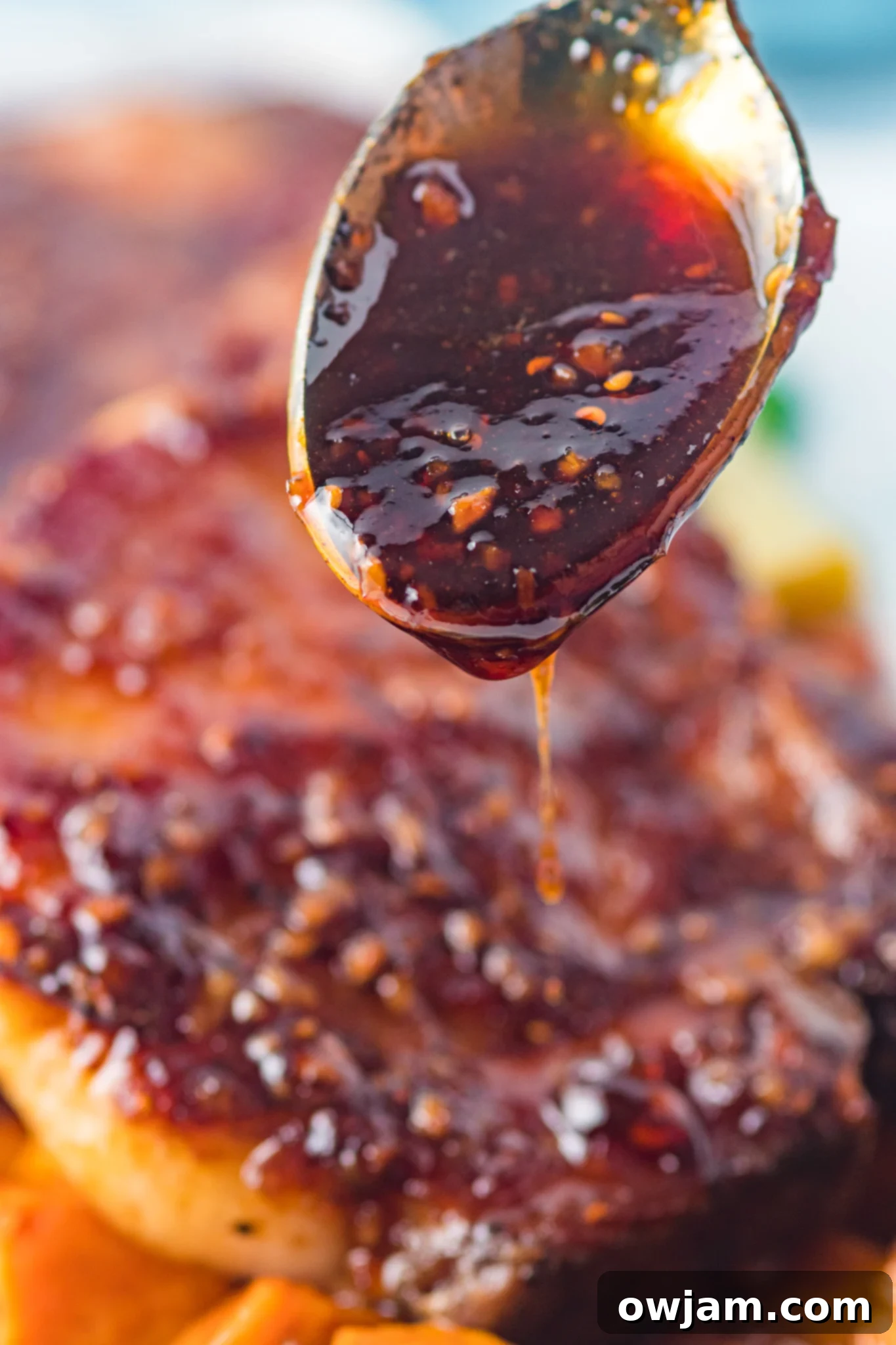 Maple Bourbon Glazed Pork Chops Recipe 5 Close-up of Maple Bourbon Pork Chops Recipe glaze on a spoon, showing its thick and glossy texture.