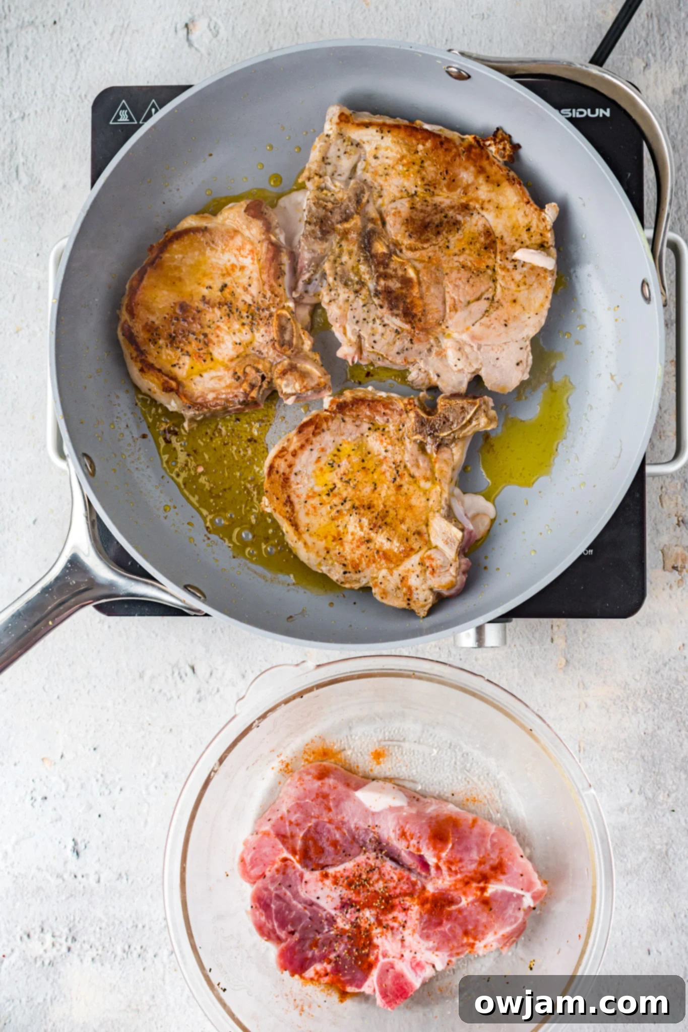 Maple Bourbon Glazed Pork Chops Recipe 9 Maple Bourbon Pork Chops Recipe searing in a skillet.