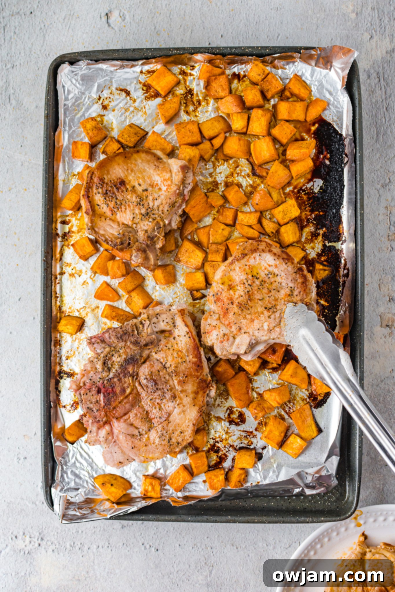 Maple Bourbon Glazed Pork Chops Recipe 10 Maple Bourbon Pork Chops Recipe being glazed with tongs.