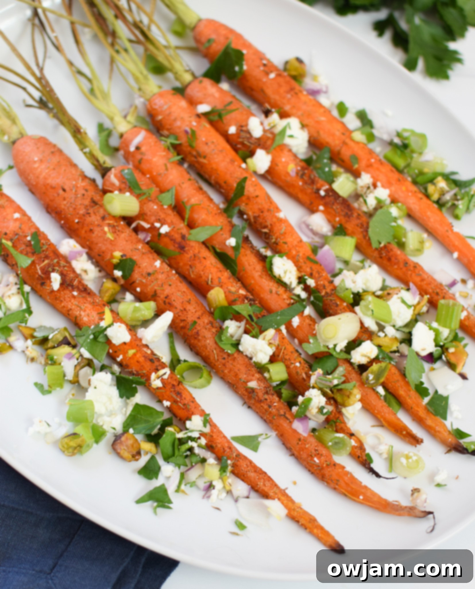 Close-up of Roasted Carrots with Pistachios and feta cheese on a serving platter.