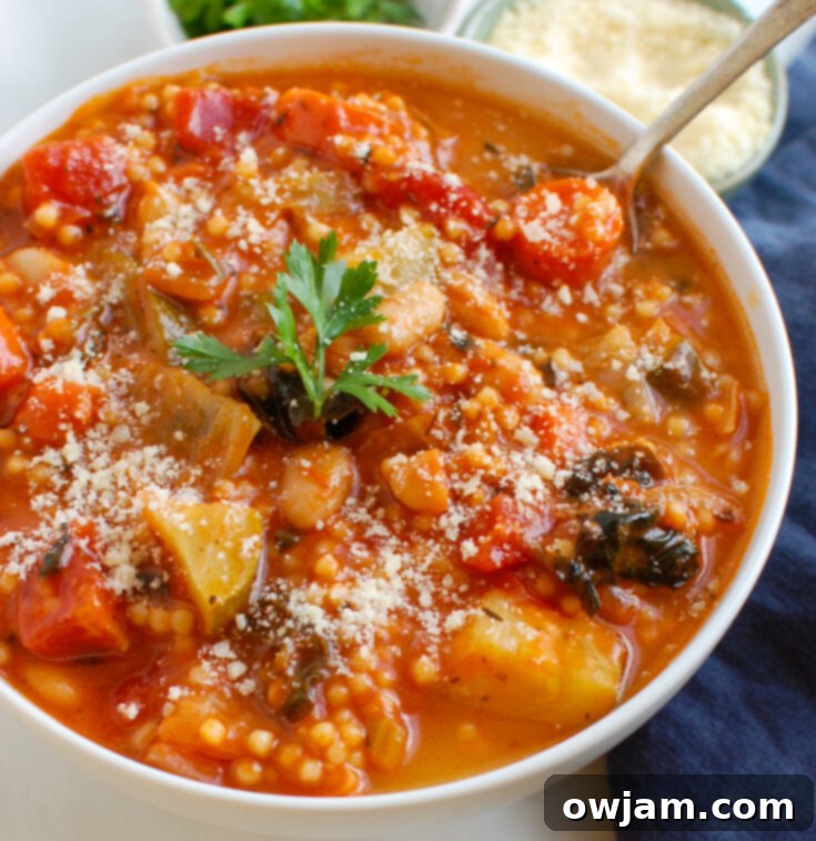 Hearty Vegetable Soup with Cabbage in a white bowl with a spoon