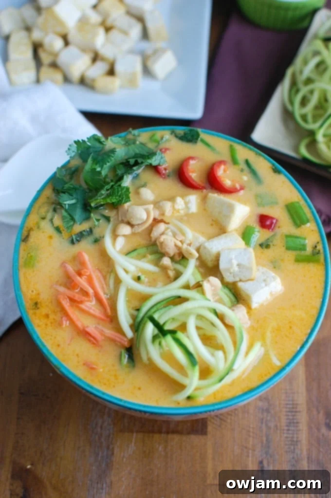 Light Thai Coconut Zoodle Soup garnished with fresh cilantro and lime