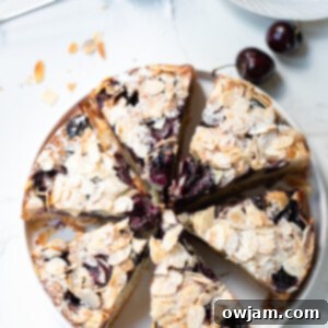 Cherry Almond Cake with cherries and almonds on a plate.