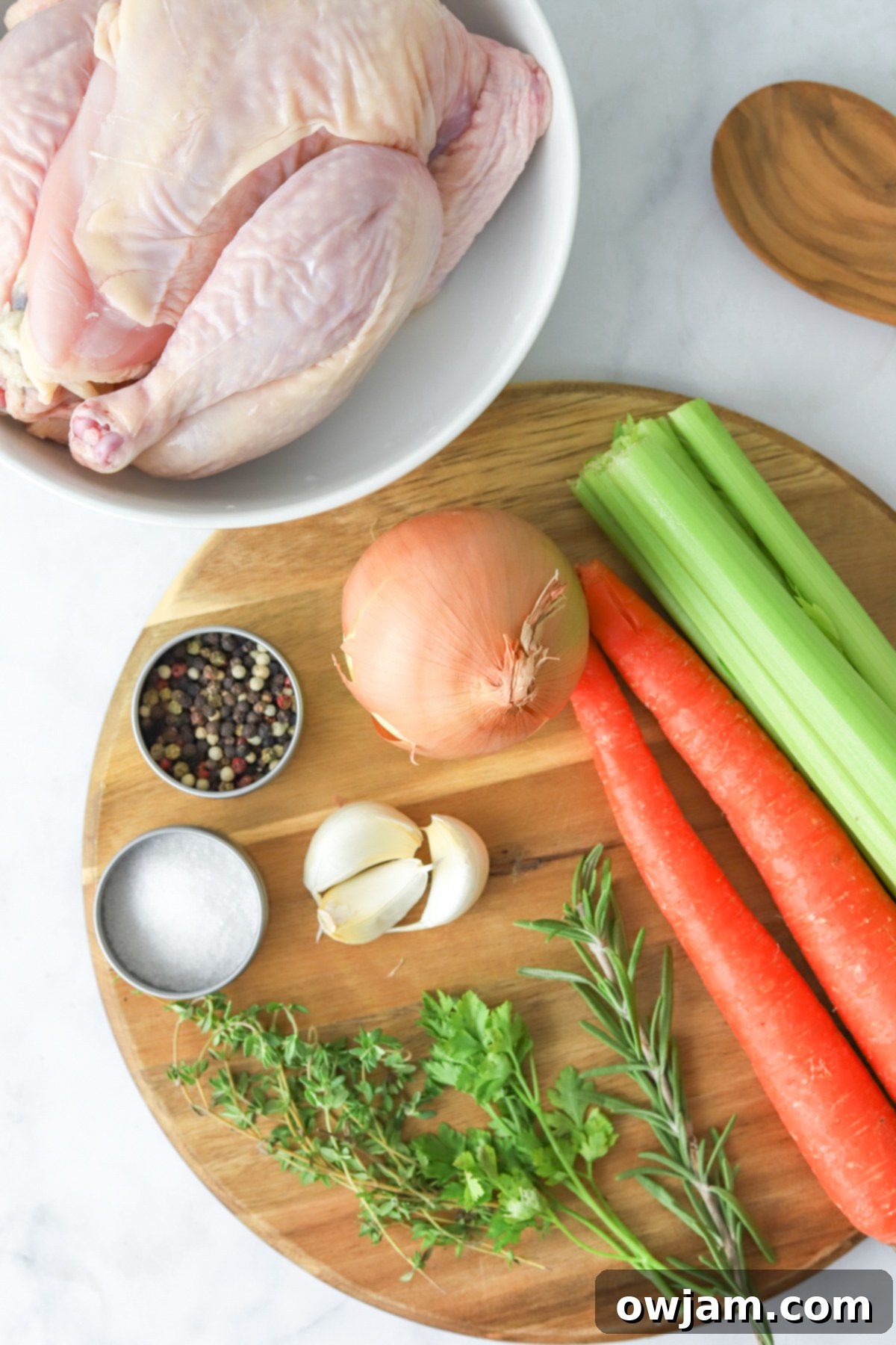 Slow-Simmered Chicken Broth 4 Collection of fresh ingredients for Homemade Chicken Broth including a whole chicken, carrots, celery, onions, garlic, and fresh herbs.