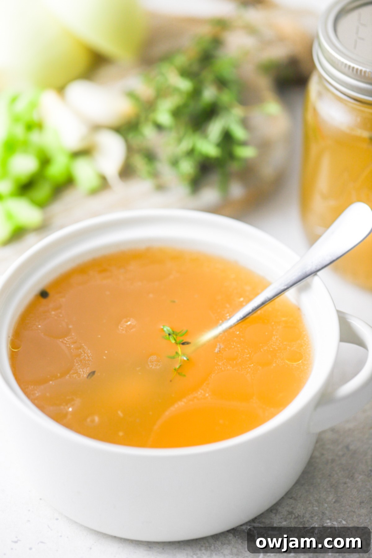 Slow-Simmered Chicken Broth 5 Homemade Chicken Broth served in a white bowl, ready to enjoy.