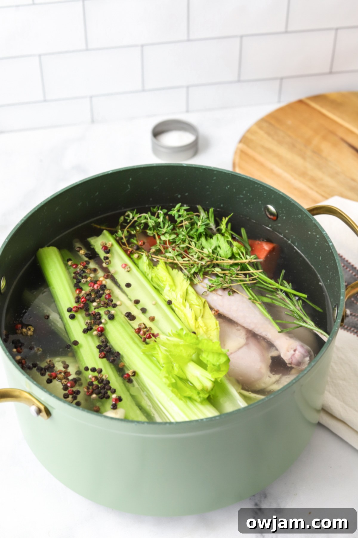 Slow-Simmered Chicken Broth 10 Homemade Chicken Broth ingredients in a pot before simmering, with a focus on fresh chicken and vibrant vegetables.