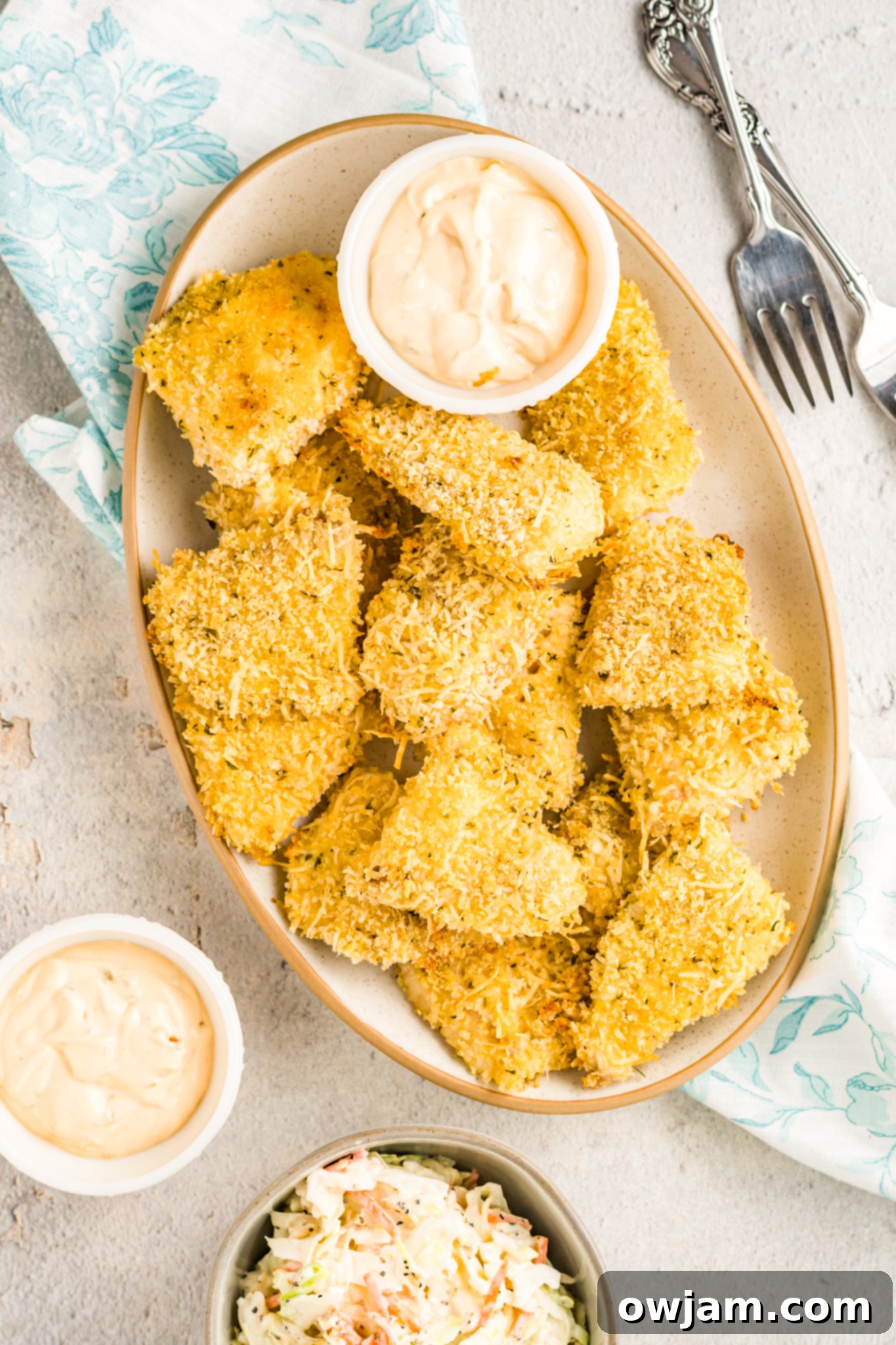 Baked Parmesan Fish Sticks piled in a rustic white bowl, ready to serve.