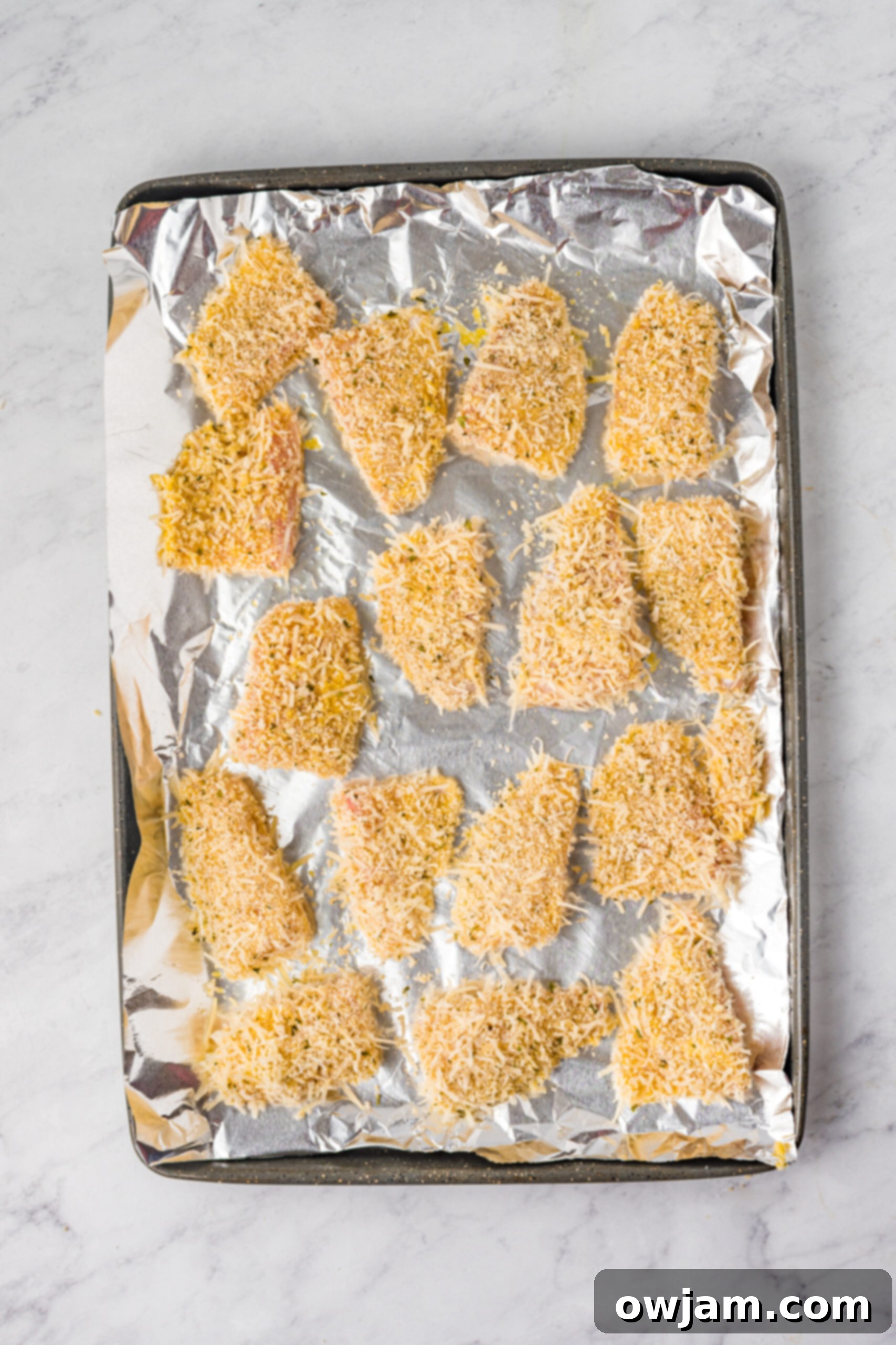 Close-up of Tilapia fish pieces being breaded.