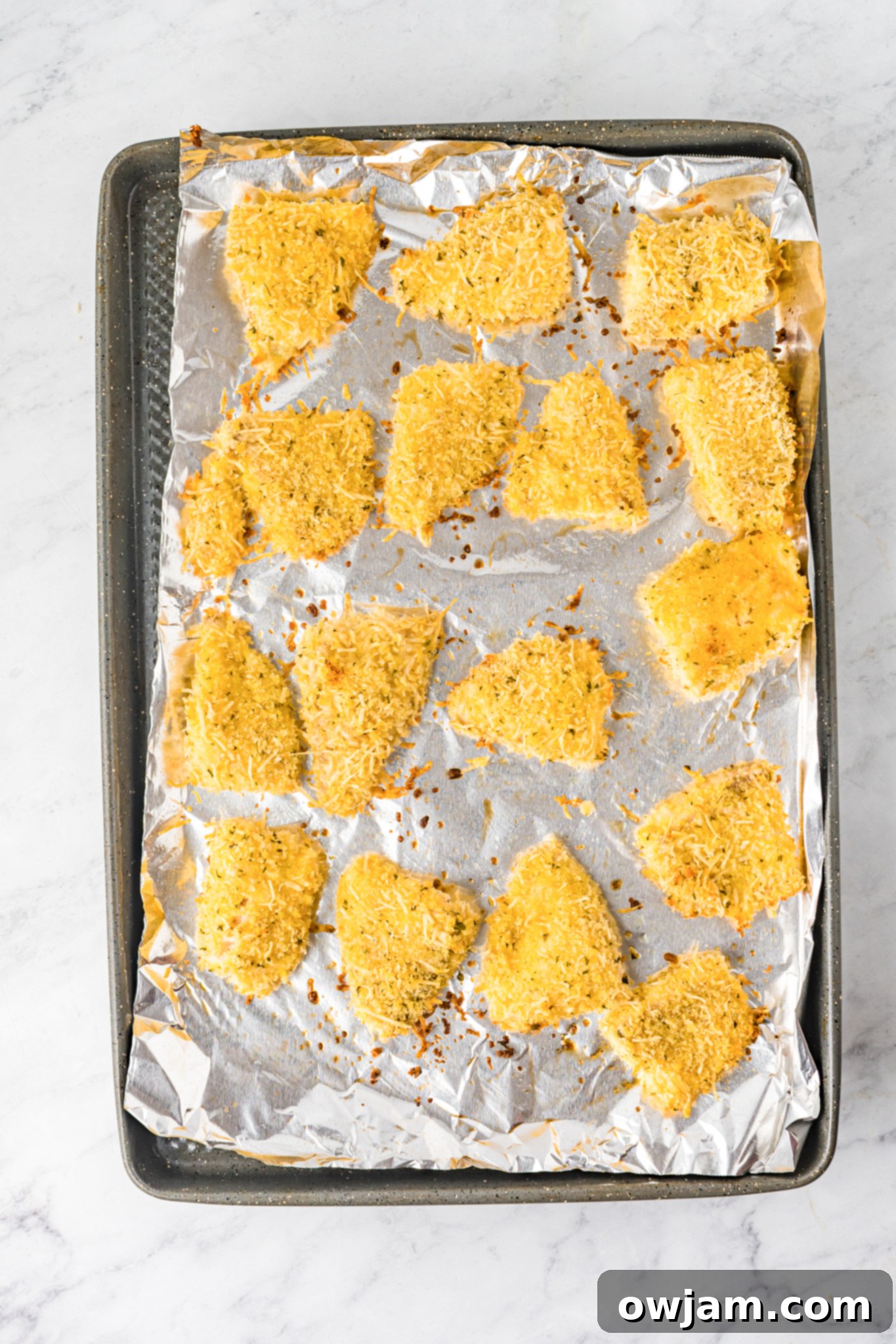 Baked Parmesan Fish Sticks baking to a perfect golden brown in the oven.