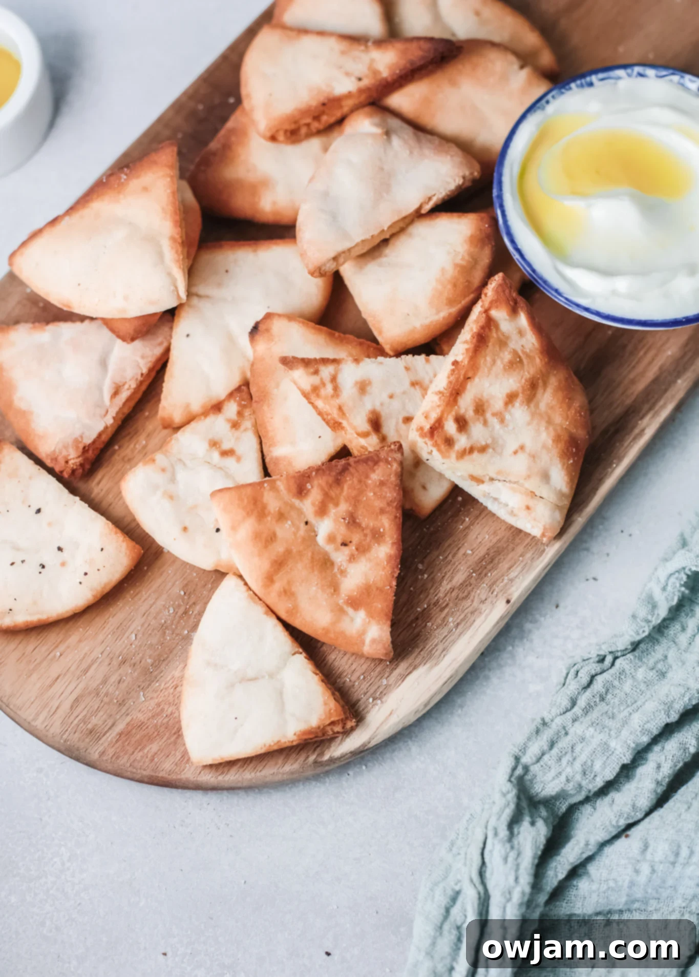 Golden Air-Fried Pita Crisps 4 Air Fryer Pita Chips served in a bowl with a side of tzatziki dip.