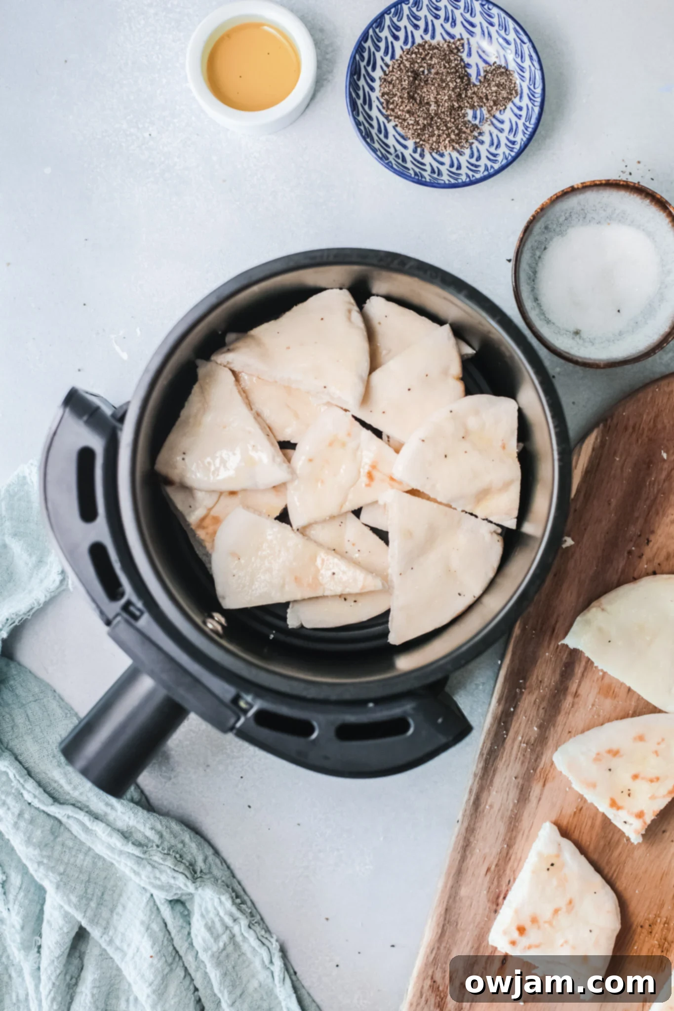 Golden Air-Fried Pita Crisps 6 Pita chips cooking in an air fryer basket, showcasing the single layer arrangement.