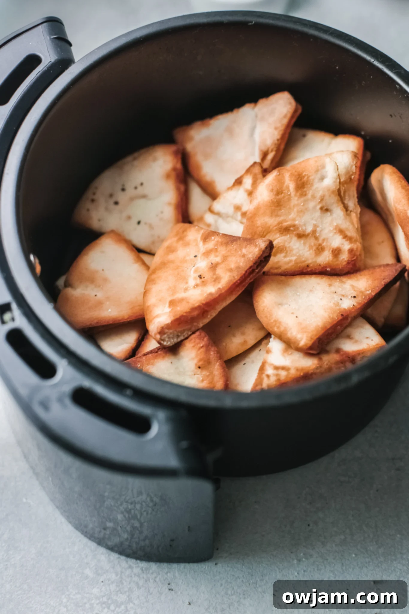 Golden Air-Fried Pita Crisps 7 Finished golden brown Air Fryer Pita Chips in the air fryer basket, perfectly crispy.