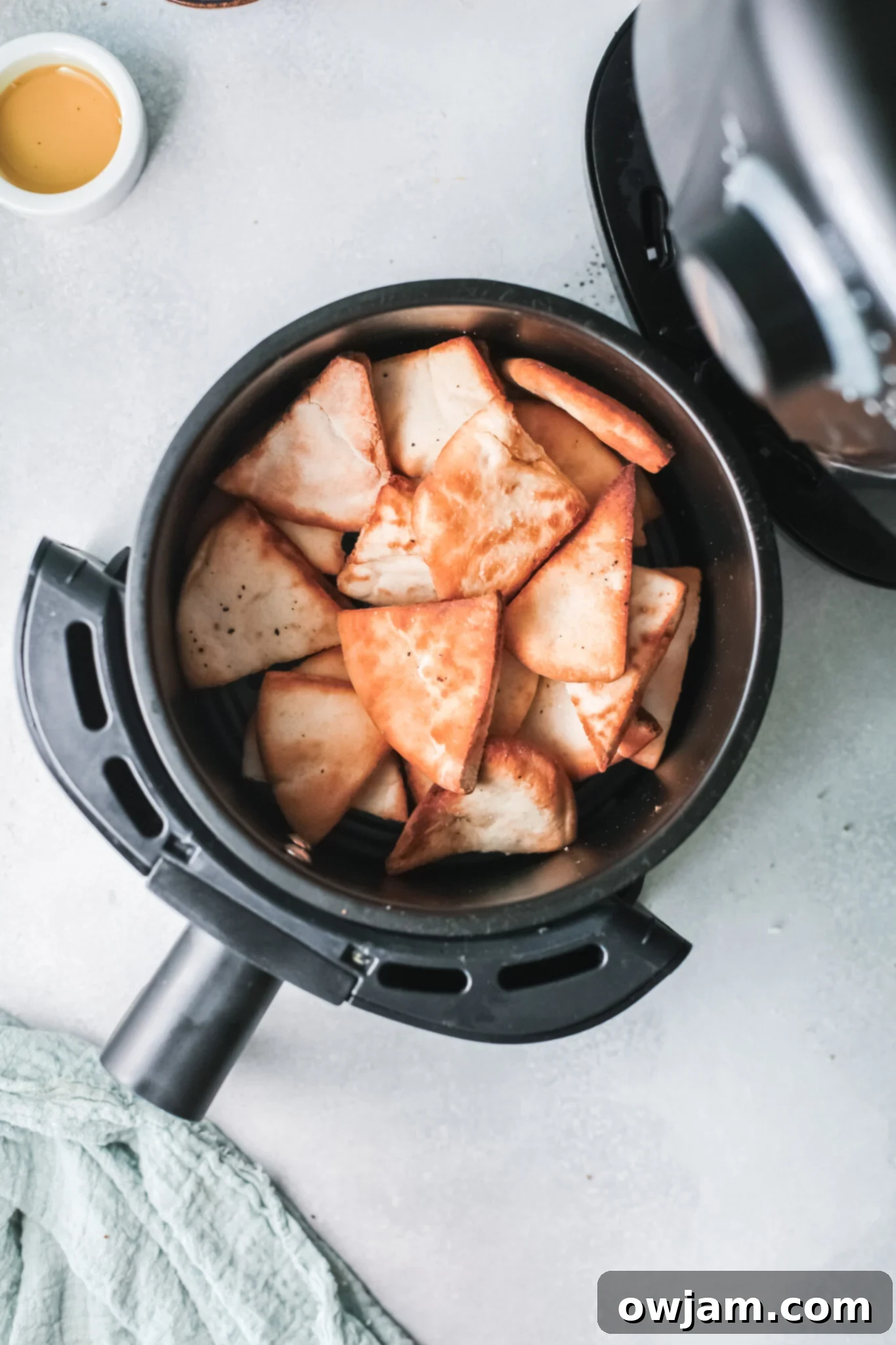 Golden Air-Fried Pita Crisps 9 Crispy Air Fryer Pita Chips in an air fryer basket, ready to be enjoyed.