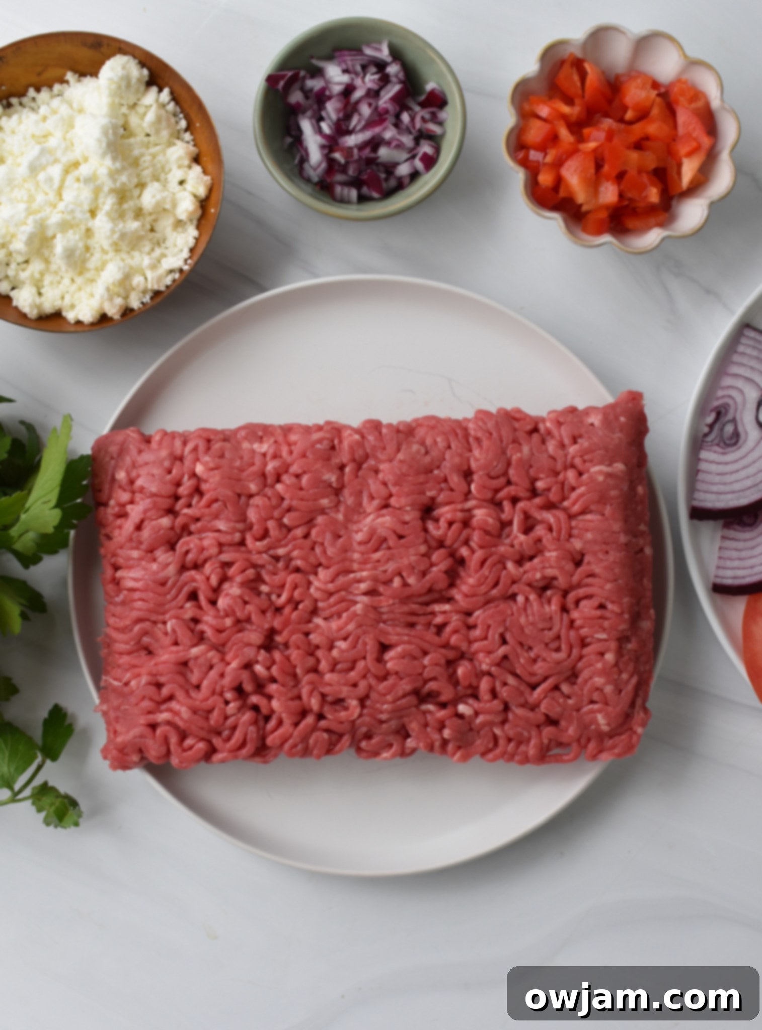 All the fresh ingredients for Feta Burger with Tzatziki gathered in bowls, ready to be mixed.