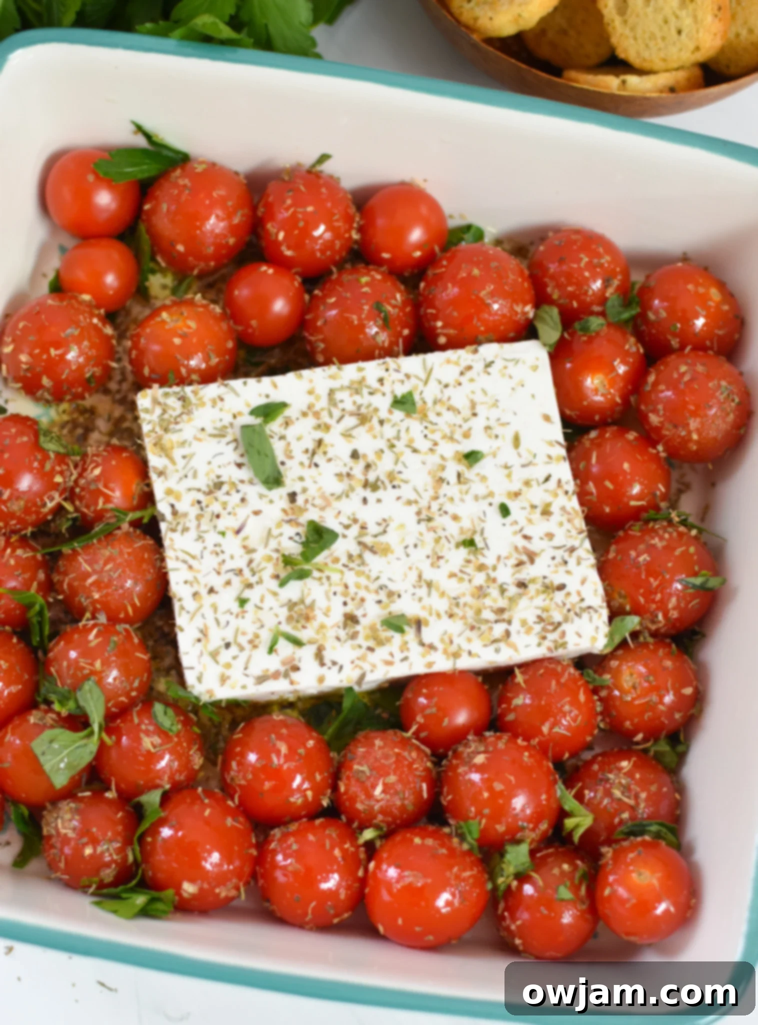 Simple Baked Feta Perfection 6 Block of feta cheese nestled among seasoned cherry tomatoes in a baking dish, ready for the oven.
