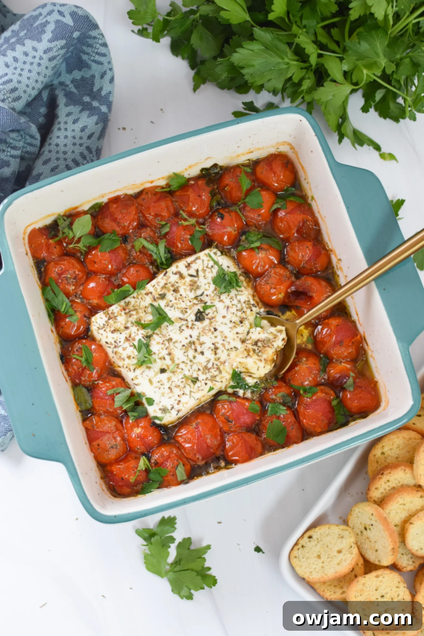 Simple Baked Feta Perfection 9 Close-up of Easy Baked Feta Recipe in a blue baking dish, showcasing the creamy feta and burst tomatoes.