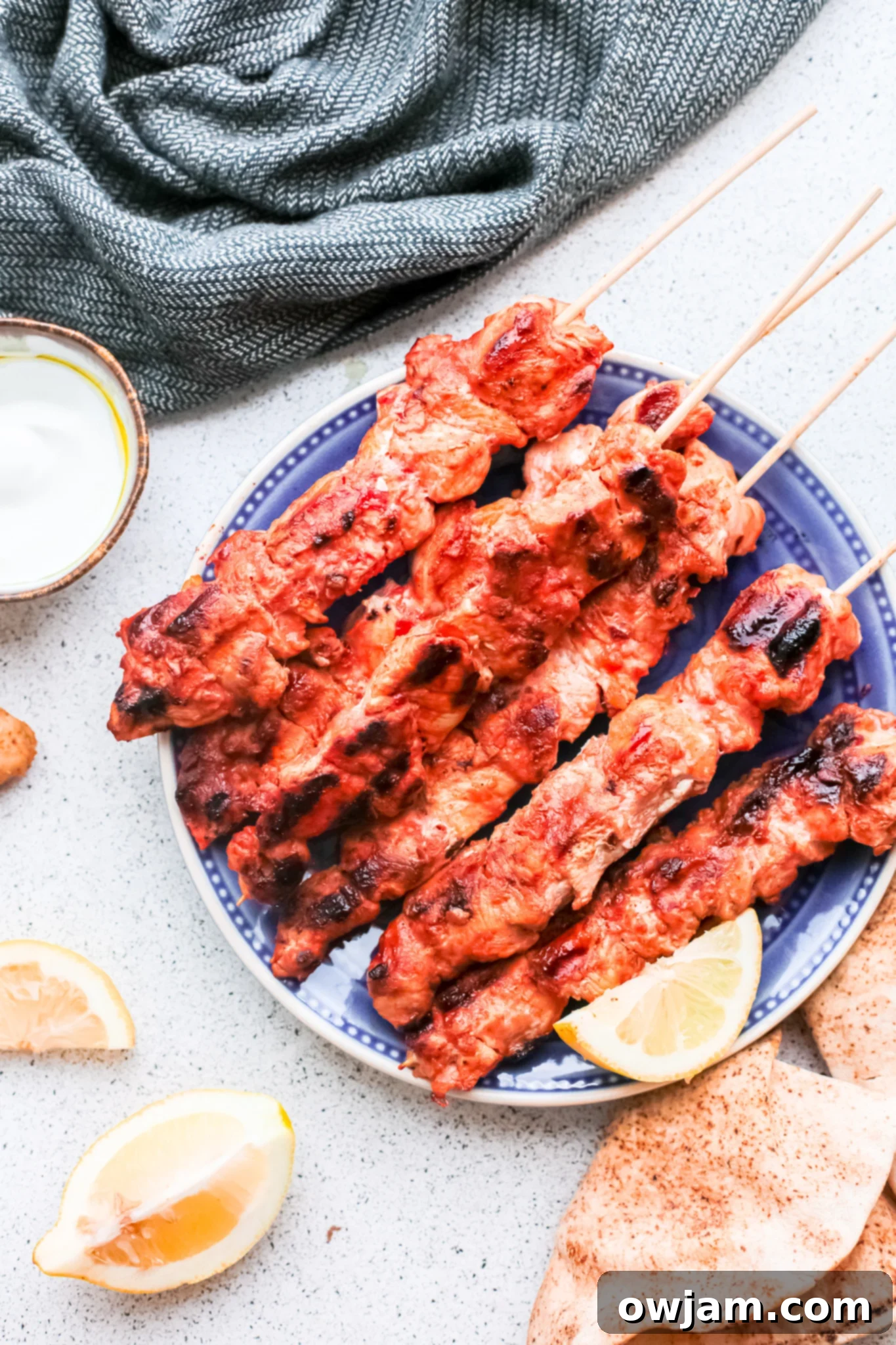 Authentic Lebanese Chicken Skewers 2 Plated Lebanese Chicken Kebabs garnished with fresh herbs and lemon wedges, ready to be served.