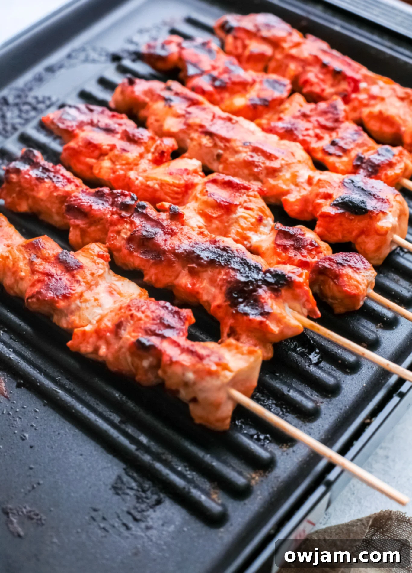 Authentic Lebanese Chicken Skewers 3 Lebanese Chicken Kebabs grilling on a hot outdoor grill, showing beautiful char marks.