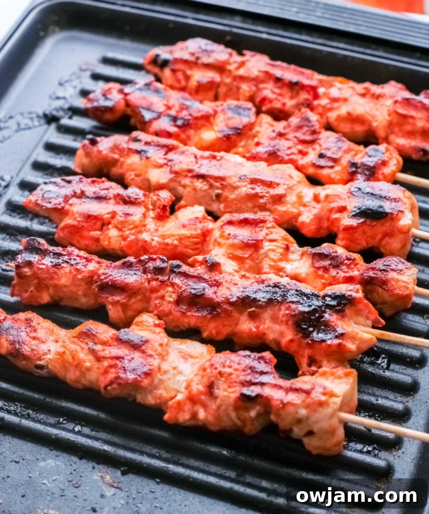 Authentic Lebanese Chicken Skewers 6 Lebanese Chicken Kebabs cooking on an outdoor grill, showing perfect charring.