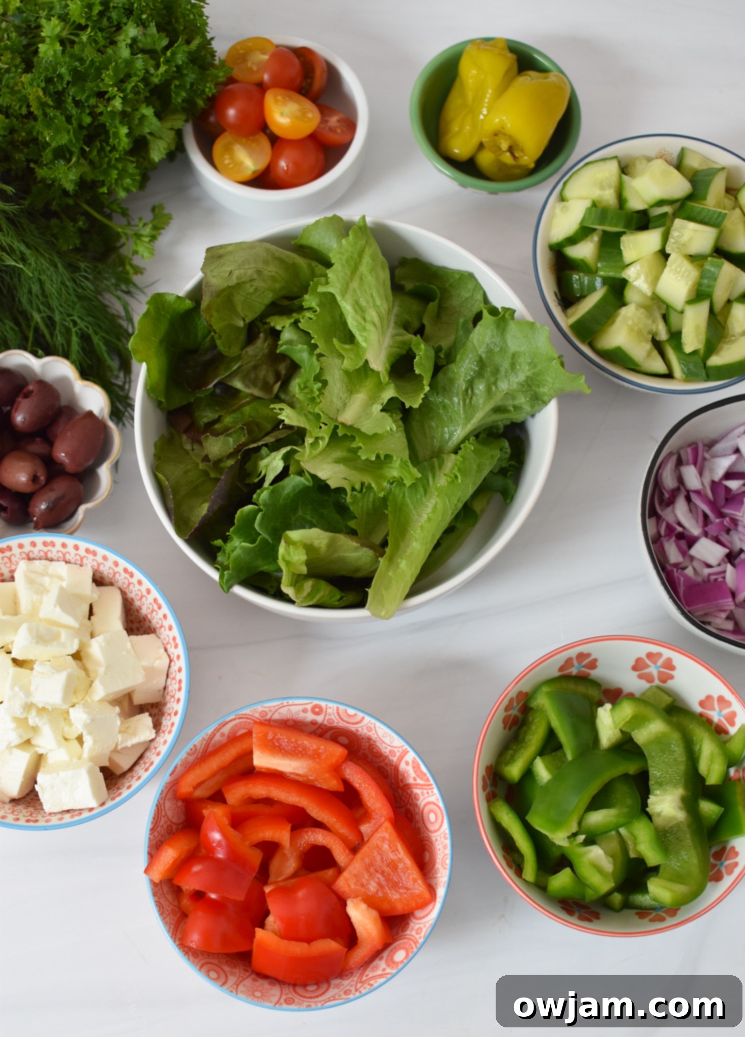 Sun-Kissed Grilled Chicken Greek Salad 3 Fresh ingredients laid out for a Grilled Chicken Greek Salad, including vegetables, feta, and herbs.