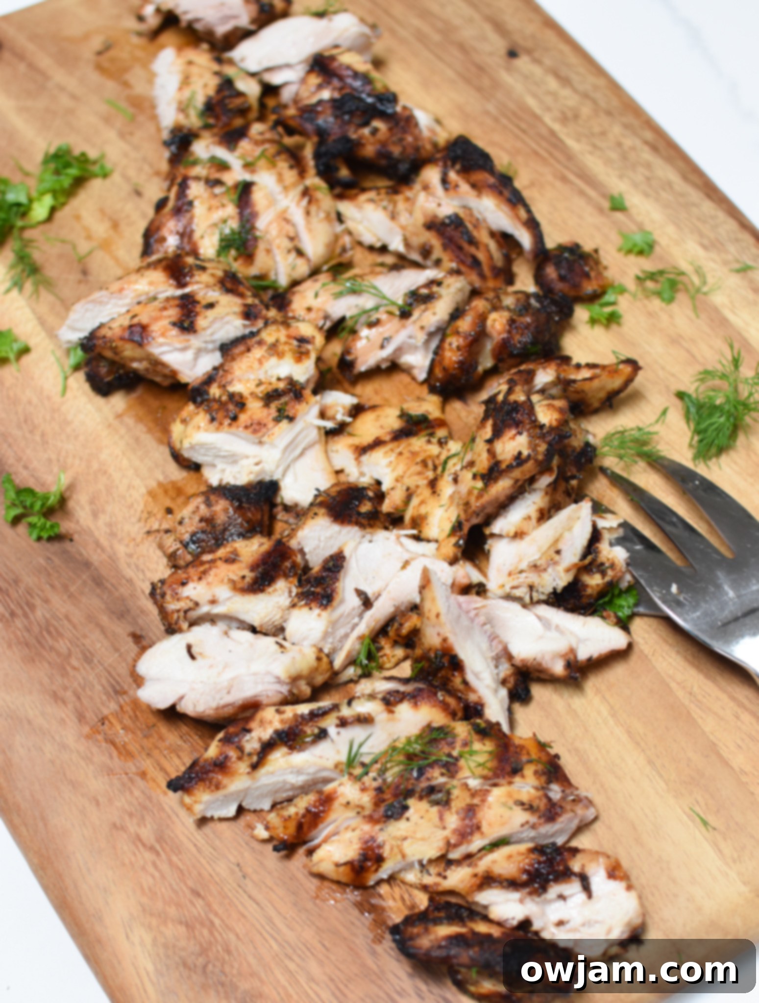 Sun-Kissed Grilled Chicken Greek Salad 8 Sliced grilled chicken on a cutting board, ready for the Greek salad.