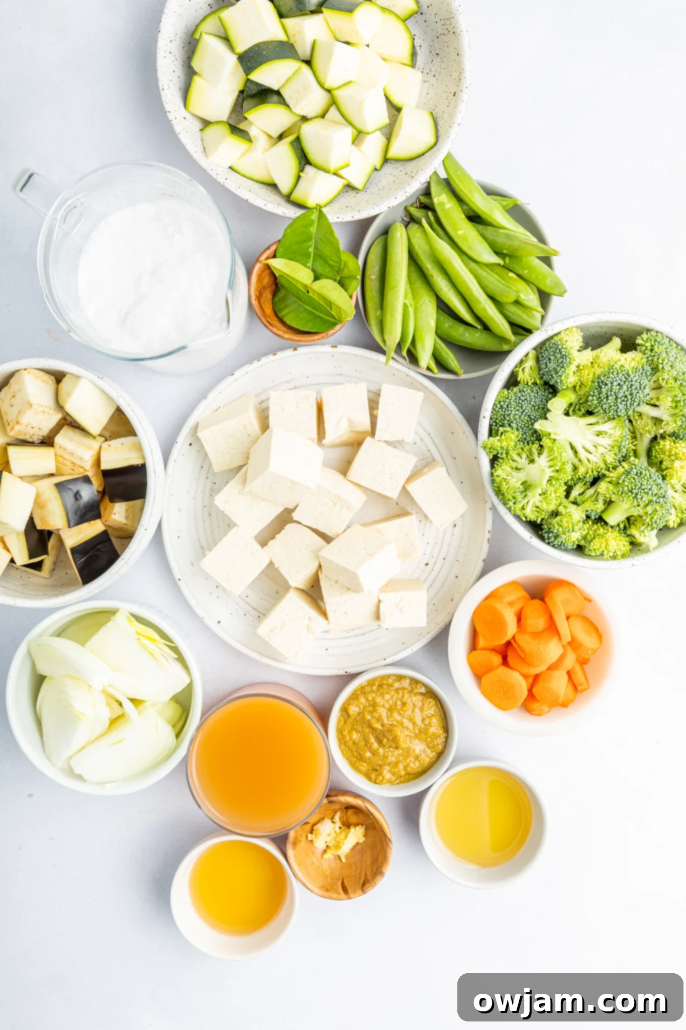 Assortment of fresh ingredients for Thai Vegetable Green Curry, including vibrant vegetables, tofu, green curry paste, and coconut milk.