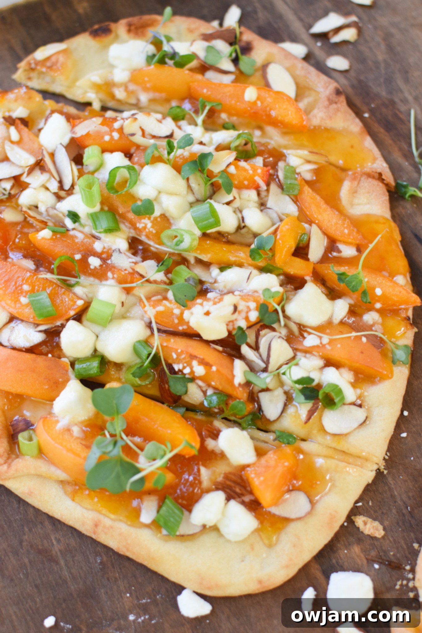 Goat Cheese Apricot Pizza freshly baked and cooling on a wooden cutting board.