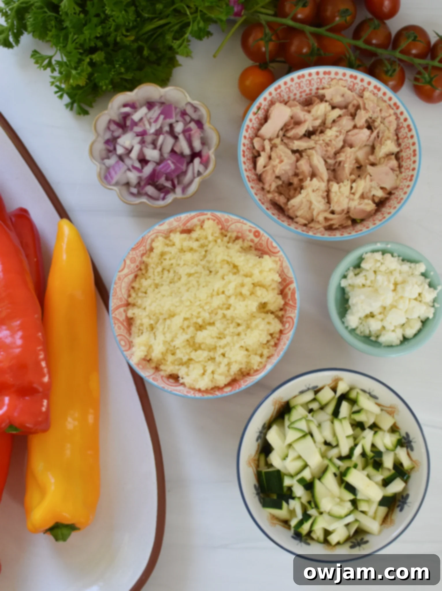 Flavorful Mediterranean Tuna Couscous Stuffed Bell Peppers 4 A selection of fresh ingredients laid out, including canned tuna, couscous, zucchini, tomatoes, feta cheese, and herbs, ready for Mediterranean Tuna Couscous Stuffed Peppers.