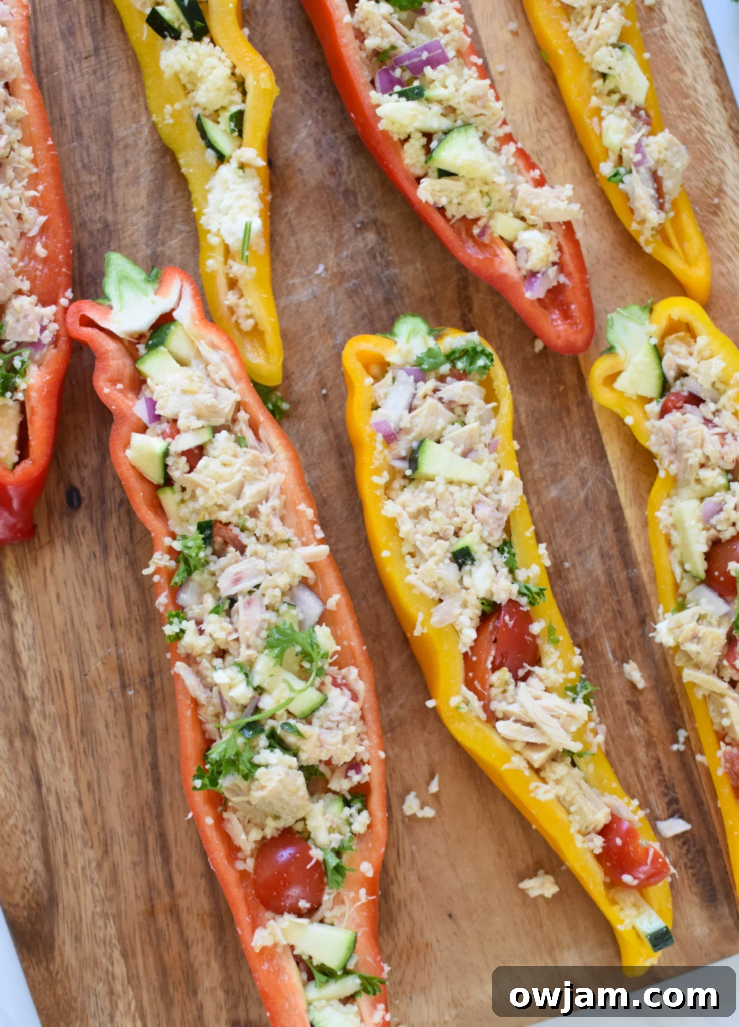 Flavorful Mediterranean Tuna Couscous Stuffed Bell Peppers 9 Halved sweet peppers, clean and ready for stuffing, arranged neatly on a wooden cutting board.