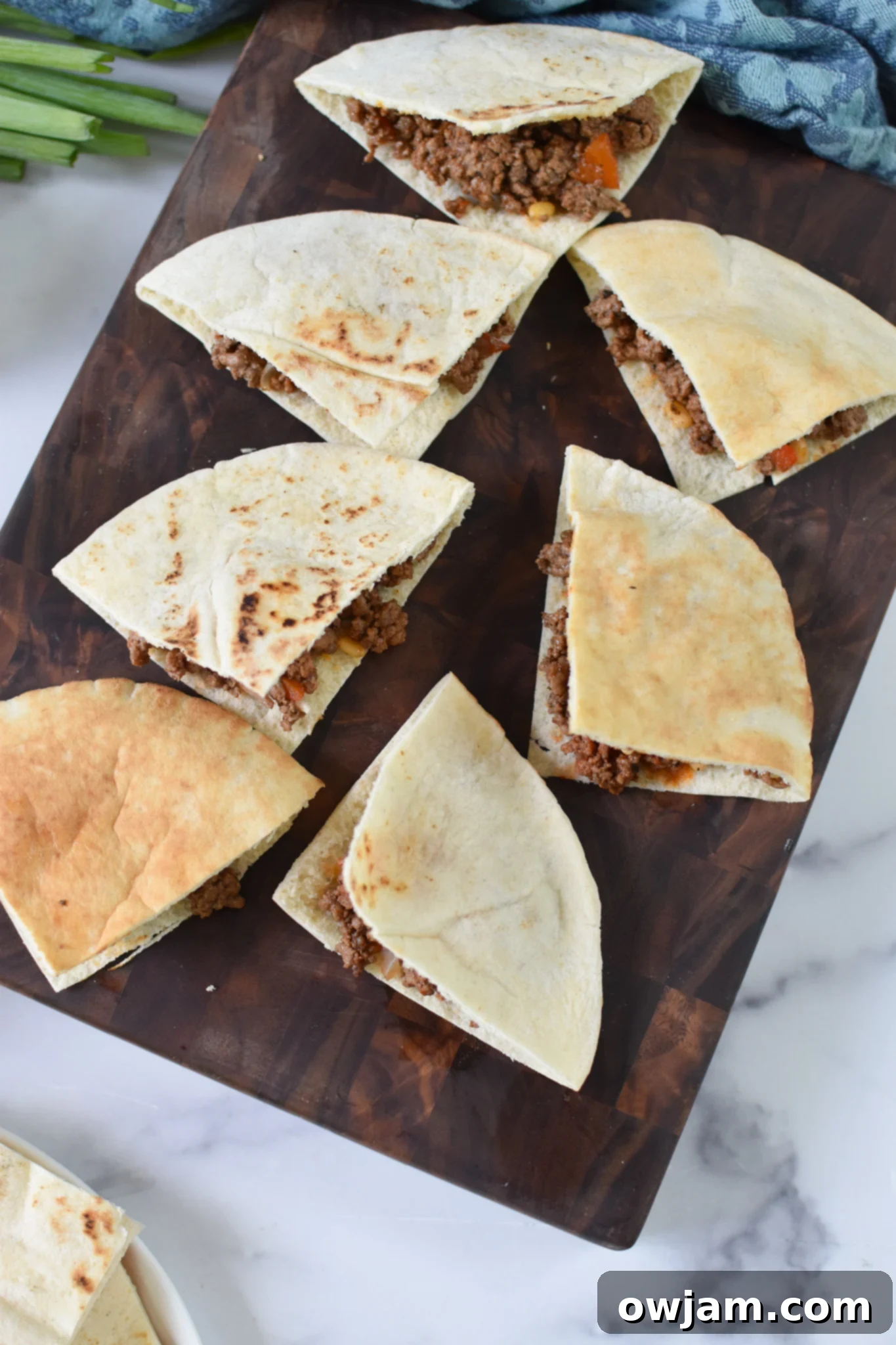 Arayes Lebanese Grilled Meat Stuffed Pitas 8 Fresh pita bread rounds laid out on a clean cutting board, ready for the savory ground beef filling to be spooned inside, preparing for Arayes.