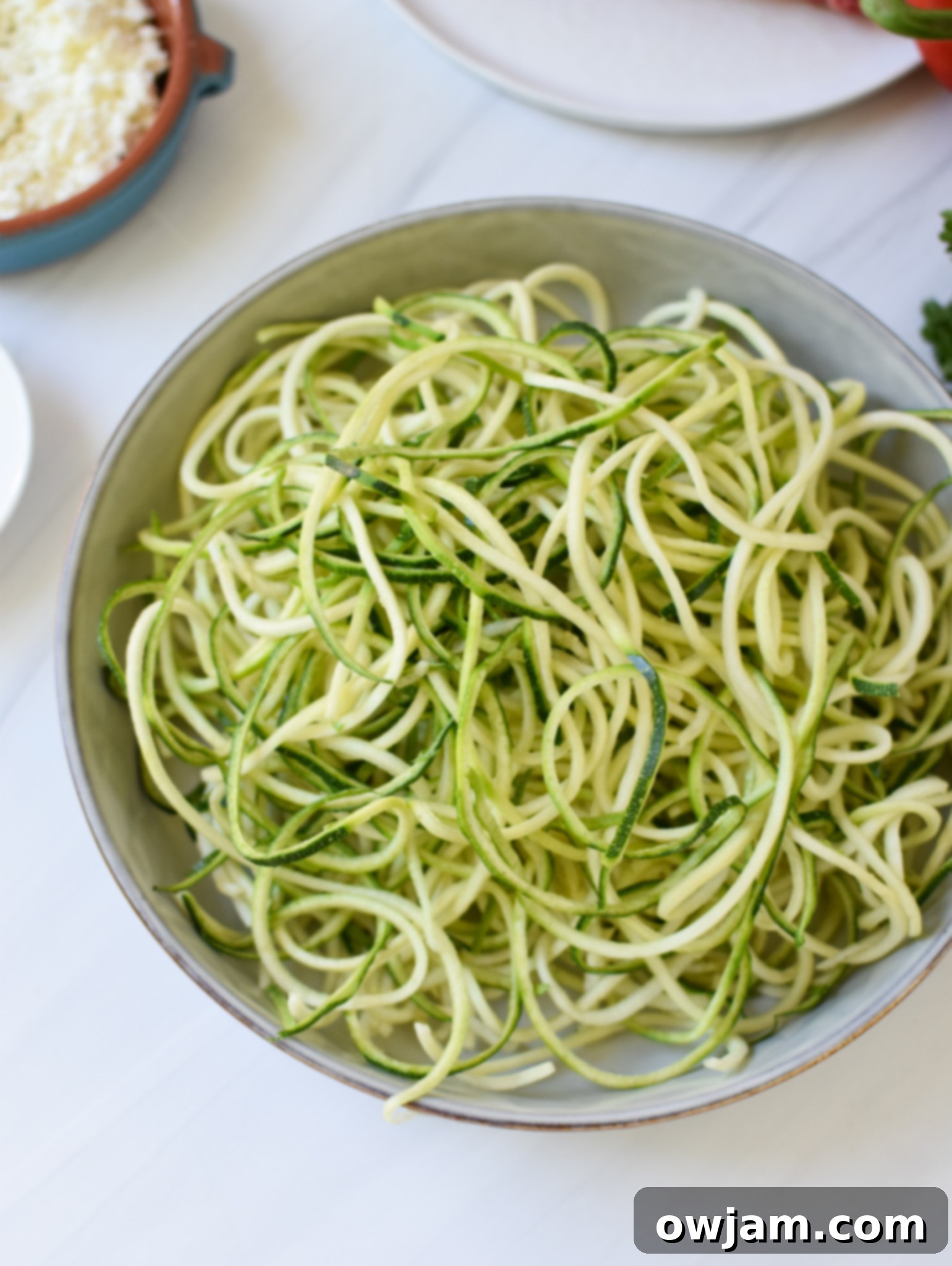 A bowl of fresh zucchini noodles, ready to be added to the Mediterranean Ground Beef Zucchini Skillet.