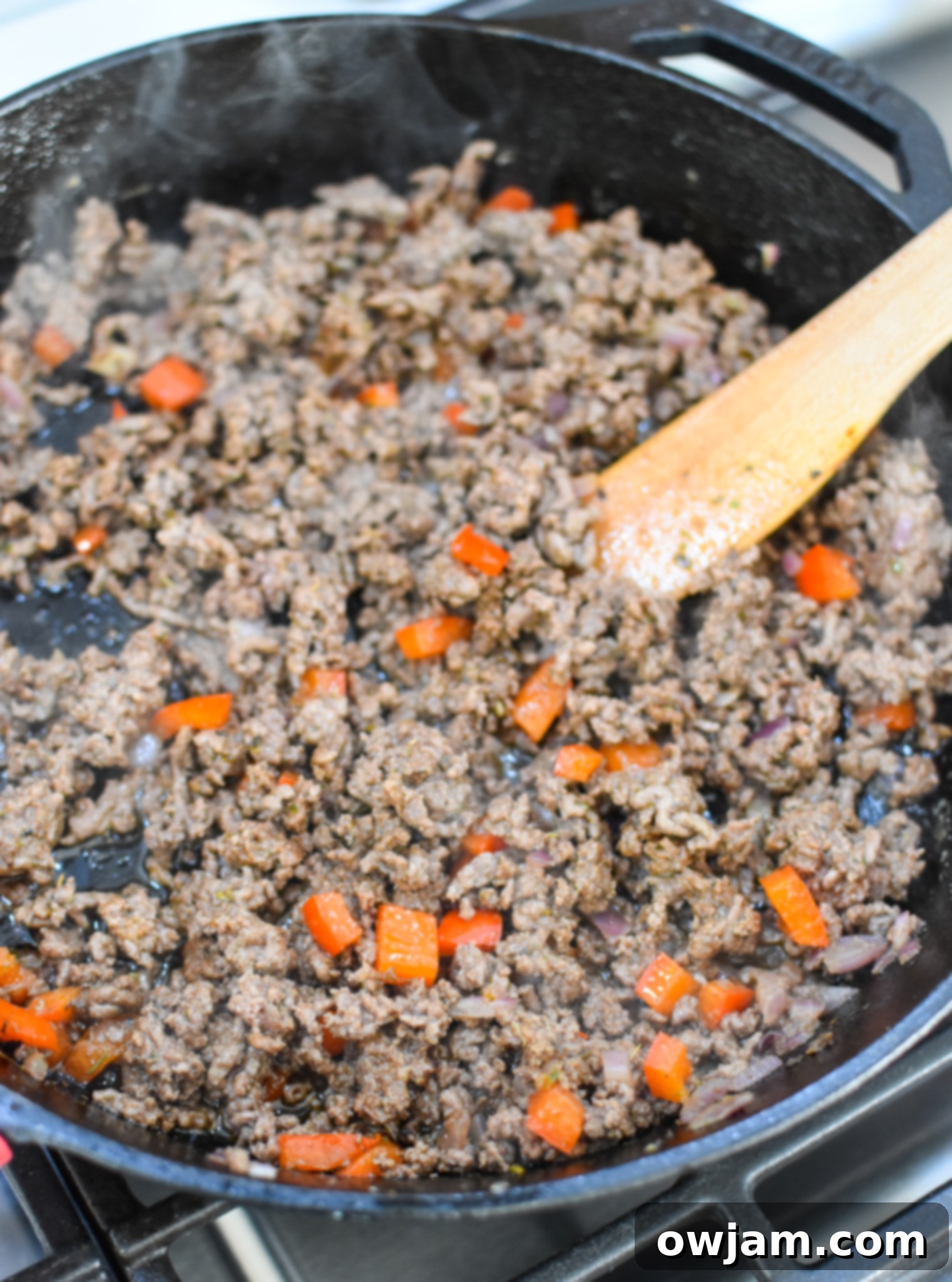 Ground beef cooking in a skillet with Mediterranean spices.