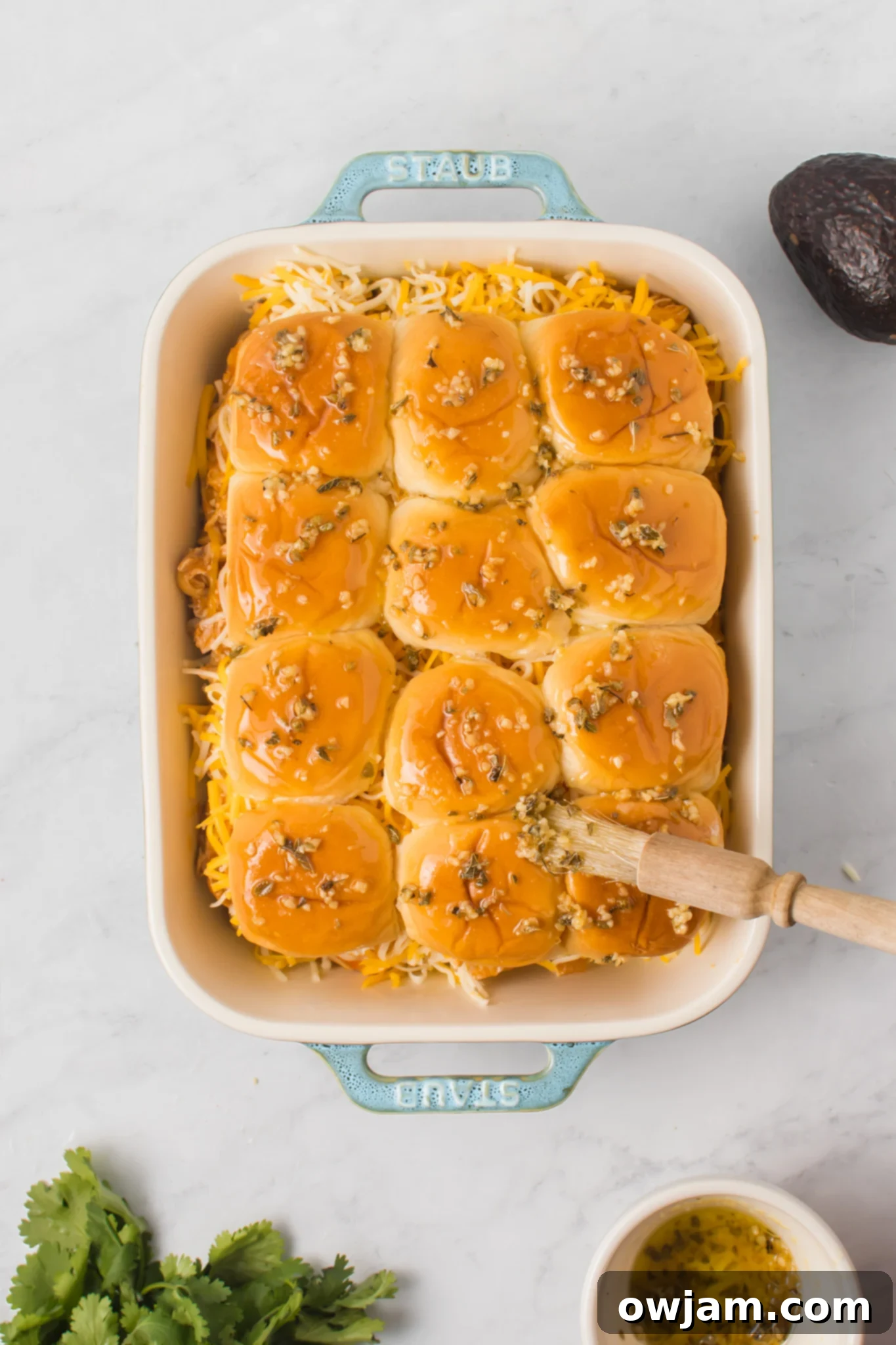Irresistible Chicken Enchilada Sliders 11 Chicken Enchilada Sliders with herb butter brushed on top of the buns.