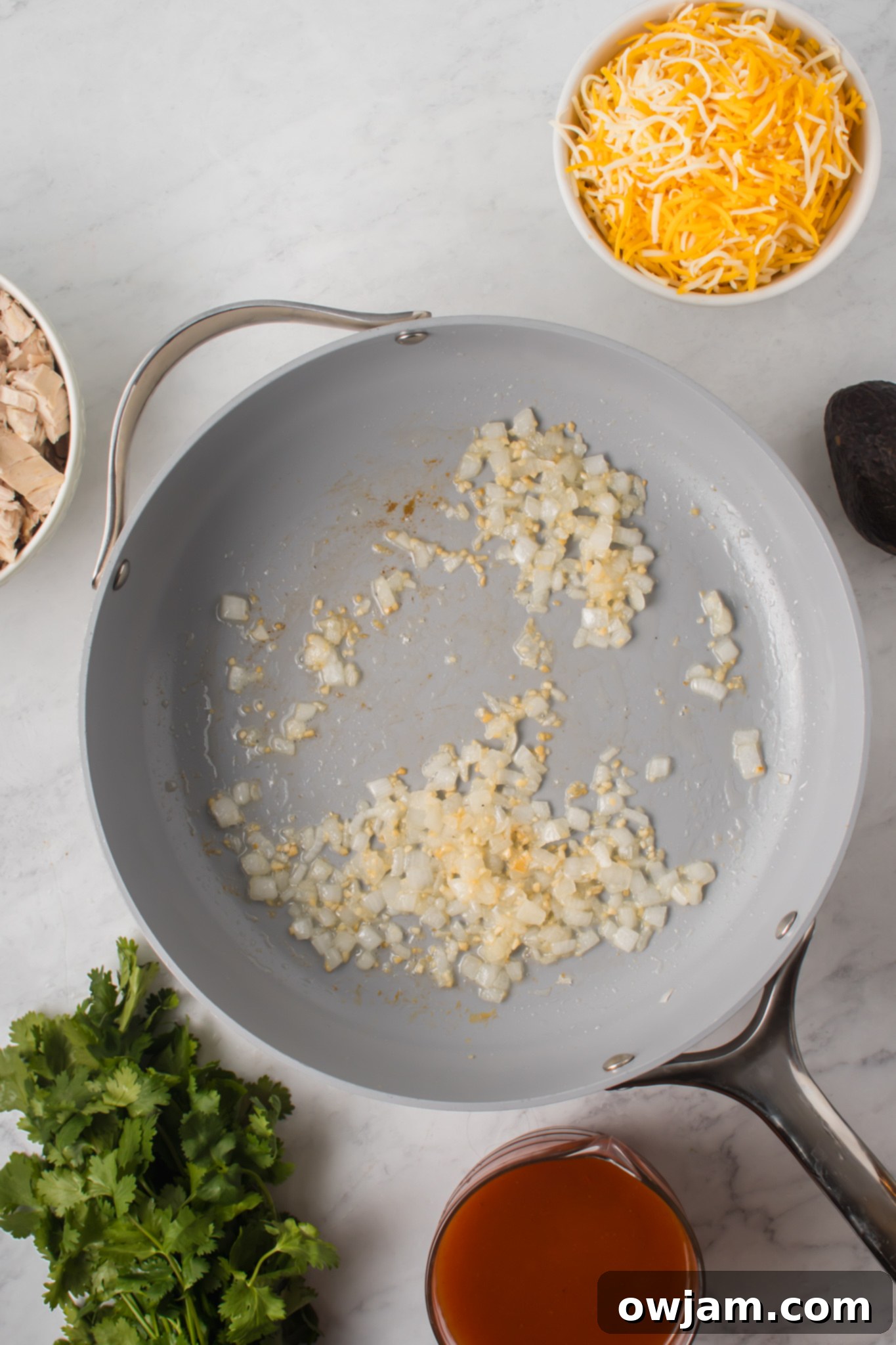 Irresistible Chicken Enchilada Sliders 5 Diced onions sautéing in a pan with olive oil.