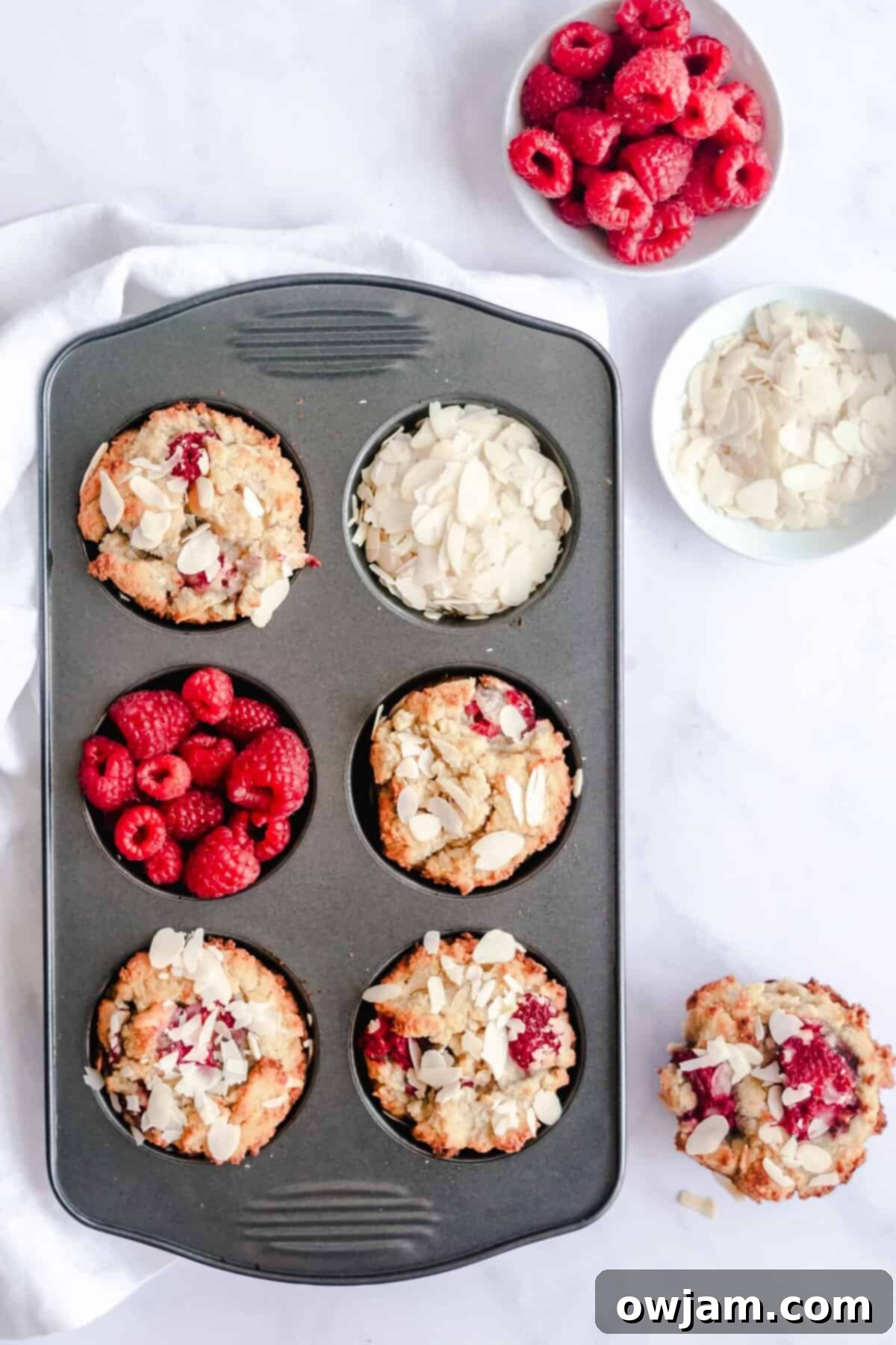 Keto Raspberry Muffins cooling on a wire rack in a muffin tin, ready for storage.