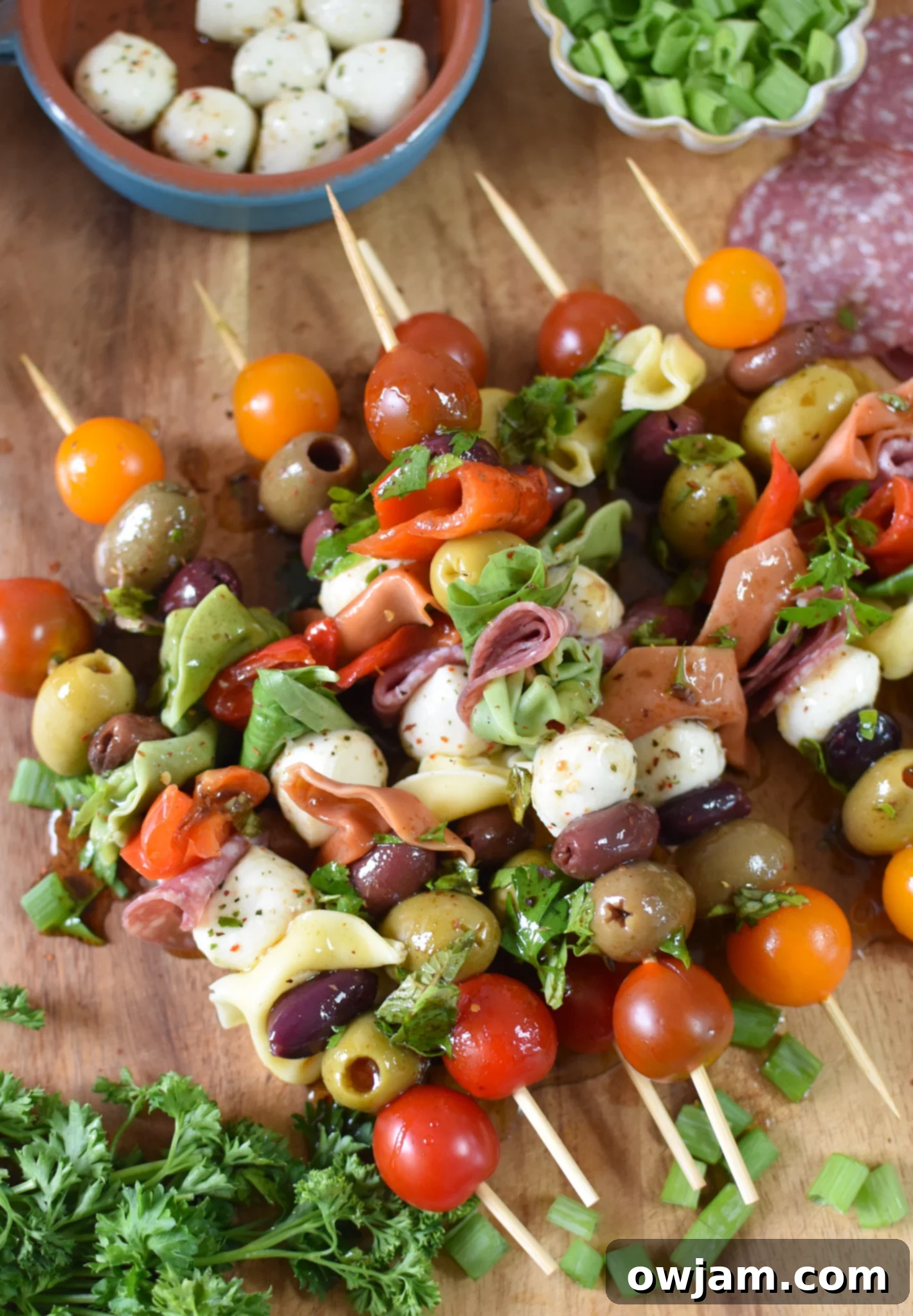Italian Skewer Medley 3 A close-up shot of colorful Antipasto Skewers laid out on a wooden cutting board.