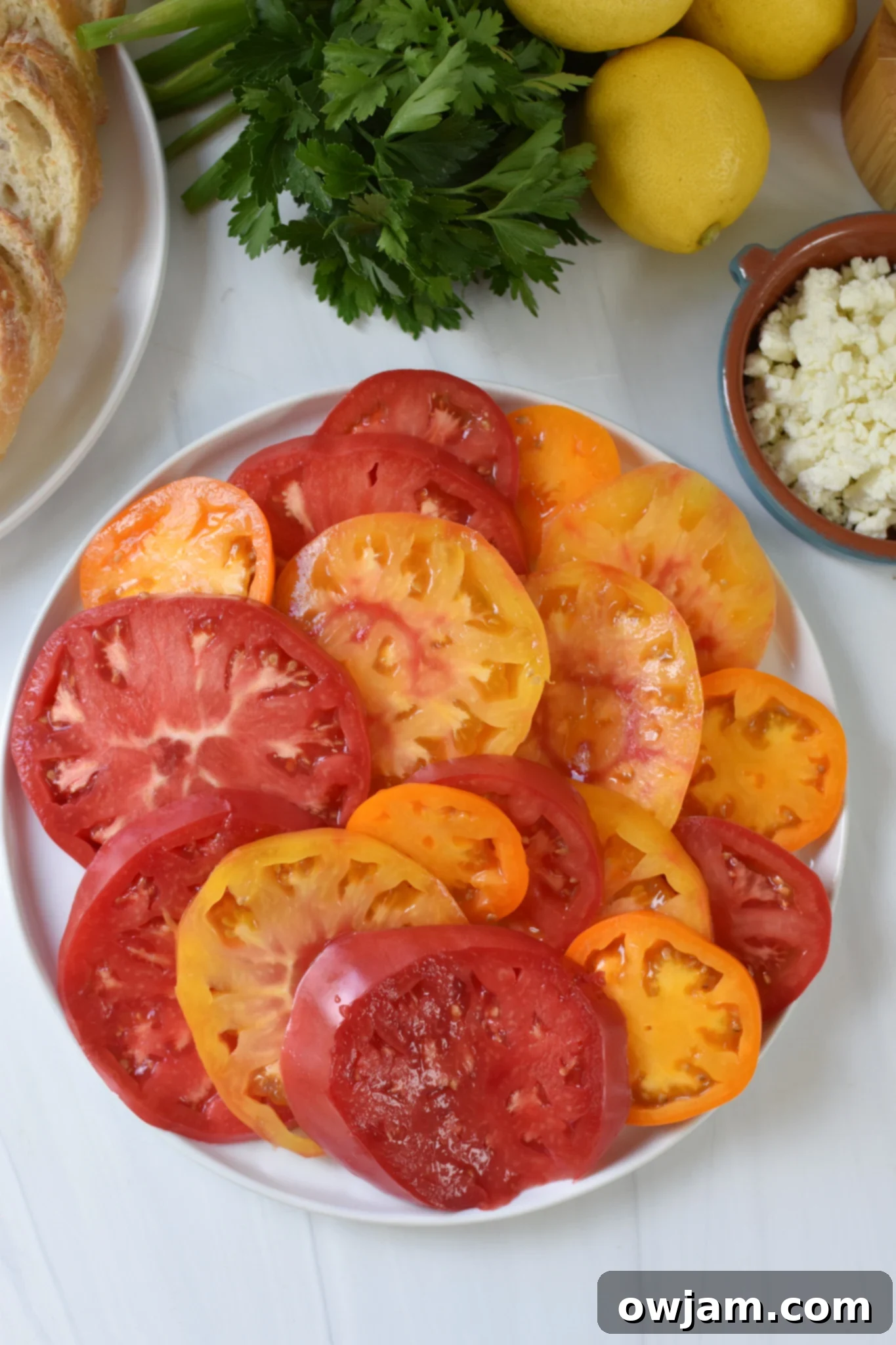 Creamy Feta Tomato Toast 4 Tomato Toast with Whipped Feta heirloom tomatoes on a white plate.