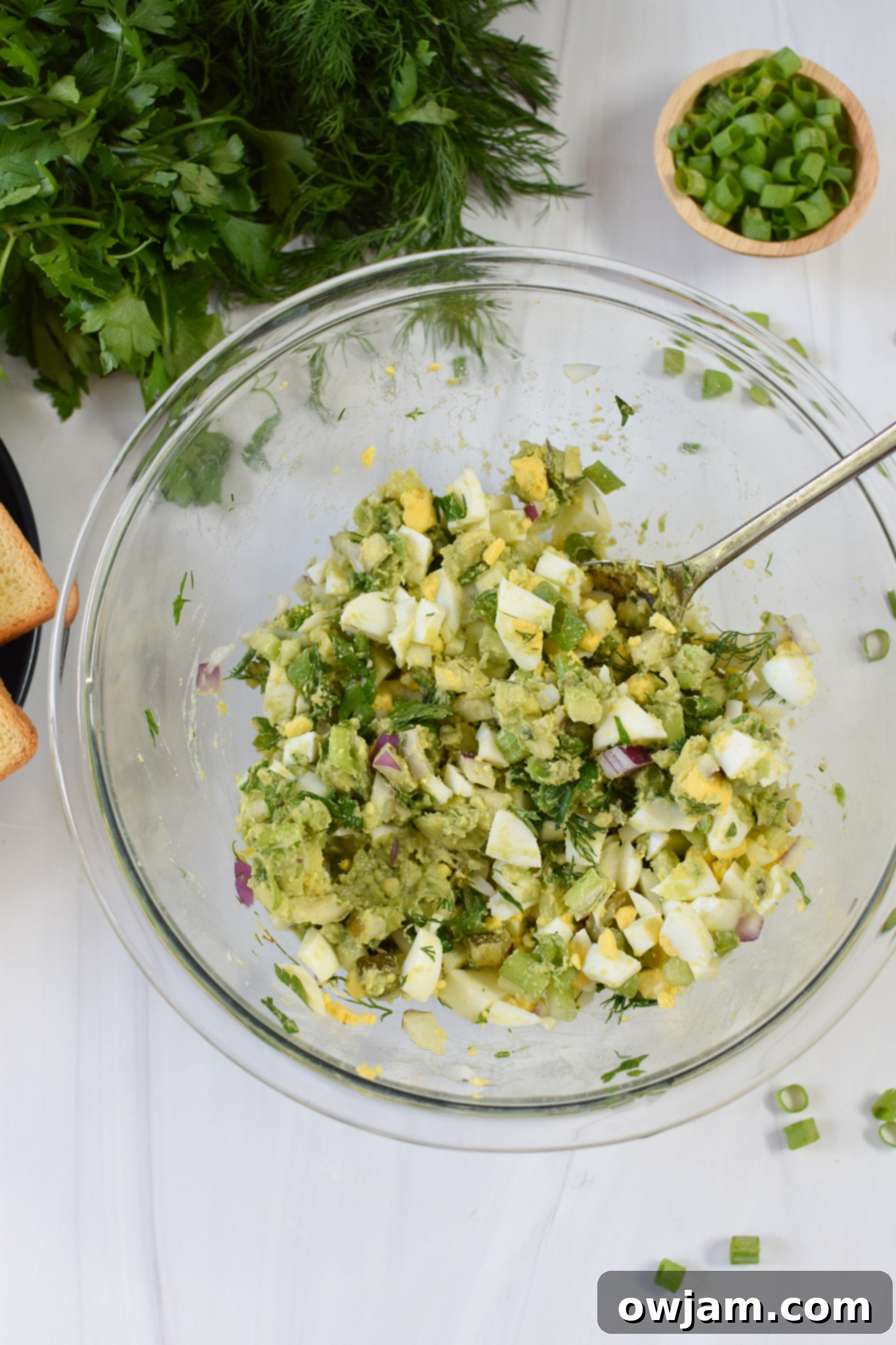 Creamy Avocado Egg Salad 6 Freshly mixed Avocado Egg Salad in a glass bowl, showcasing its creamy texture and vibrant colors.