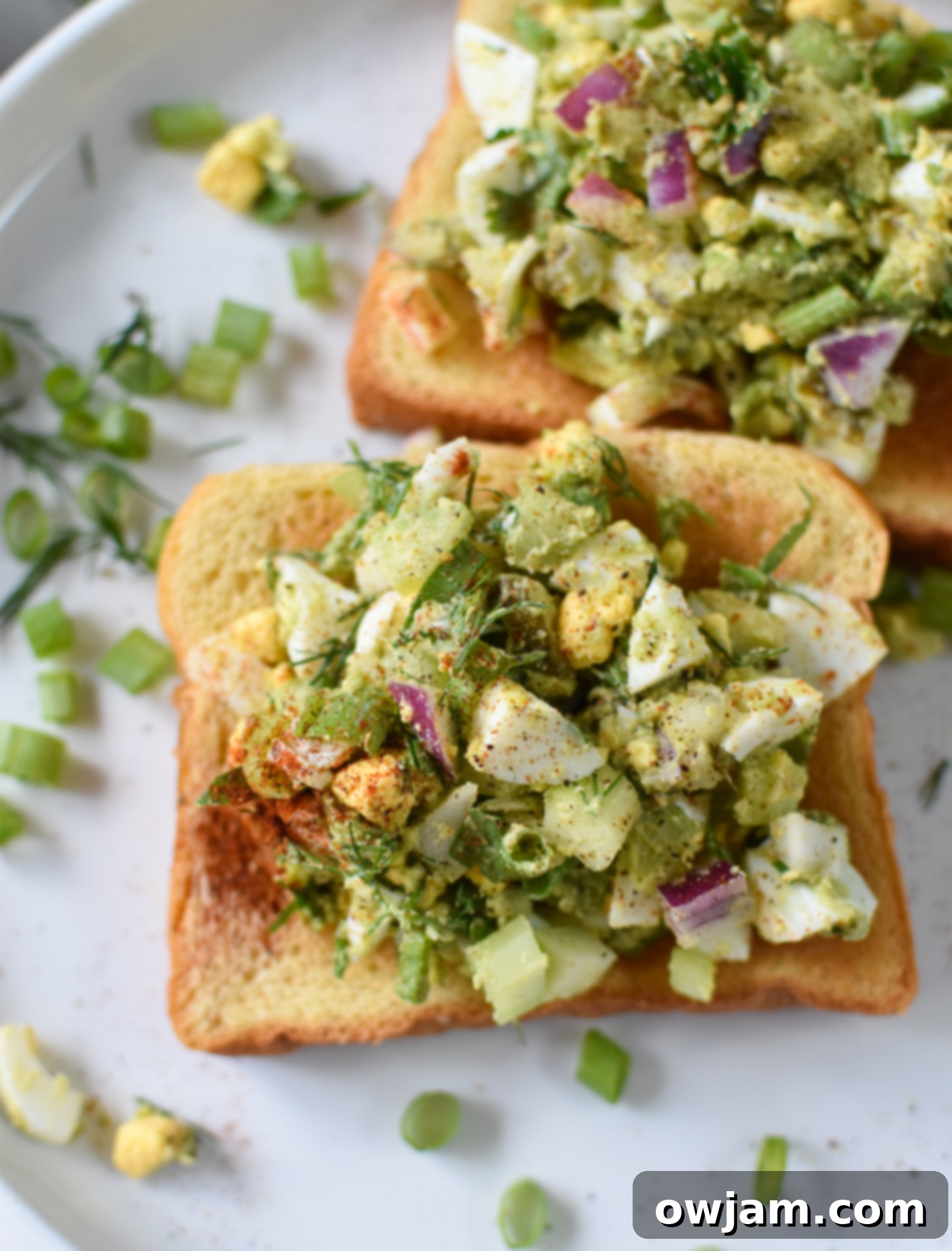Creamy Avocado Egg Salad 9 Appetizing Avocado Egg Salad generously spread on toasted bread, ready to be enjoyed.