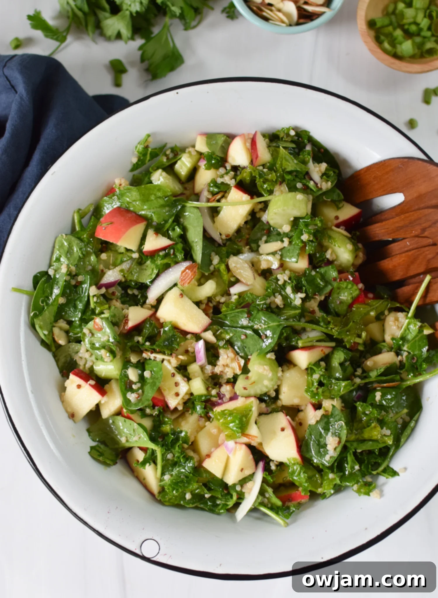 Nourishing Apple Kale Quinoa Salad 5 Apple Kale Quinoa Salad with wooden serving spoons.