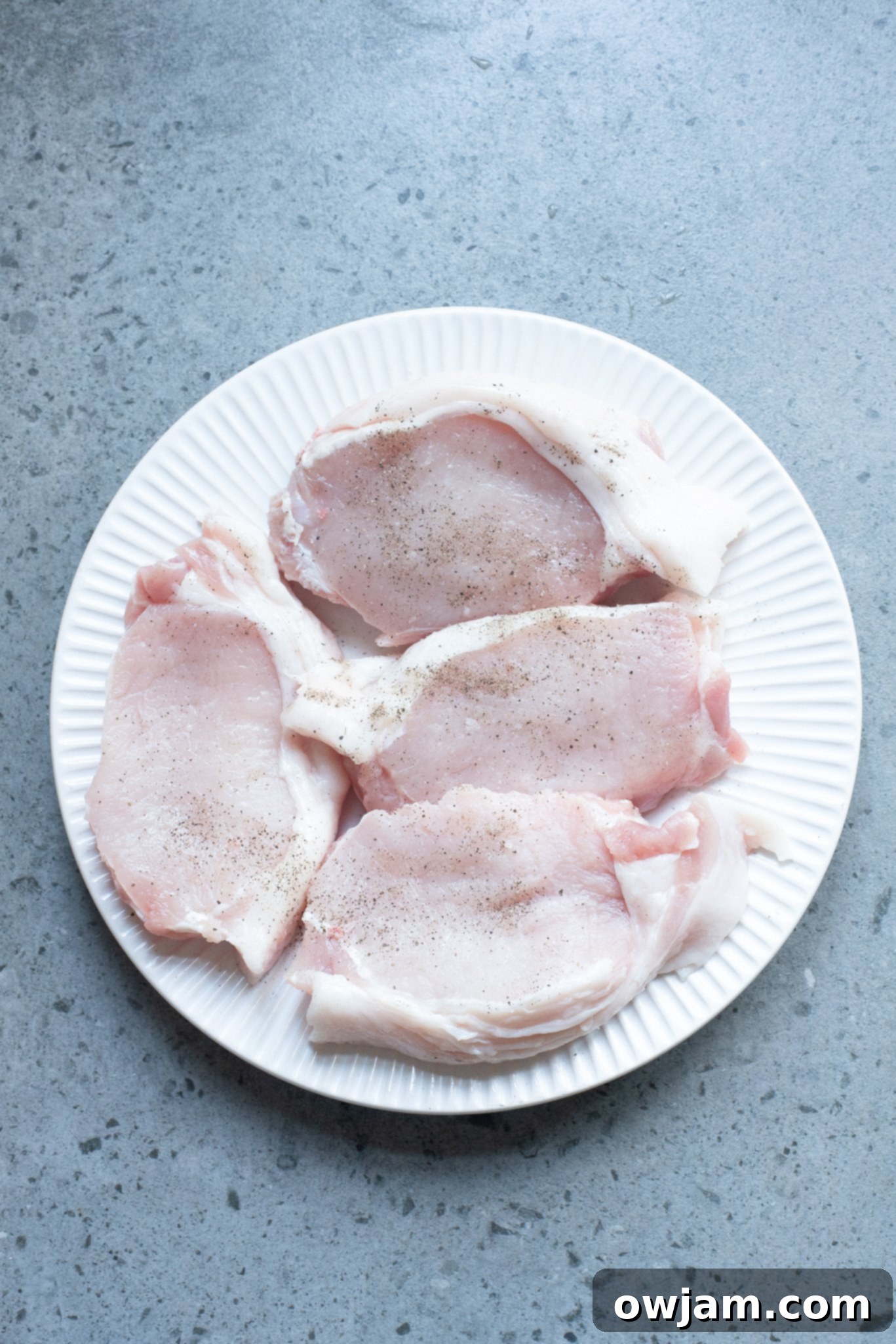 Sweet and Savory Pineapple Pork Chops 5 Boneless pork chops searing in a hot skillet, developing a golden crust.