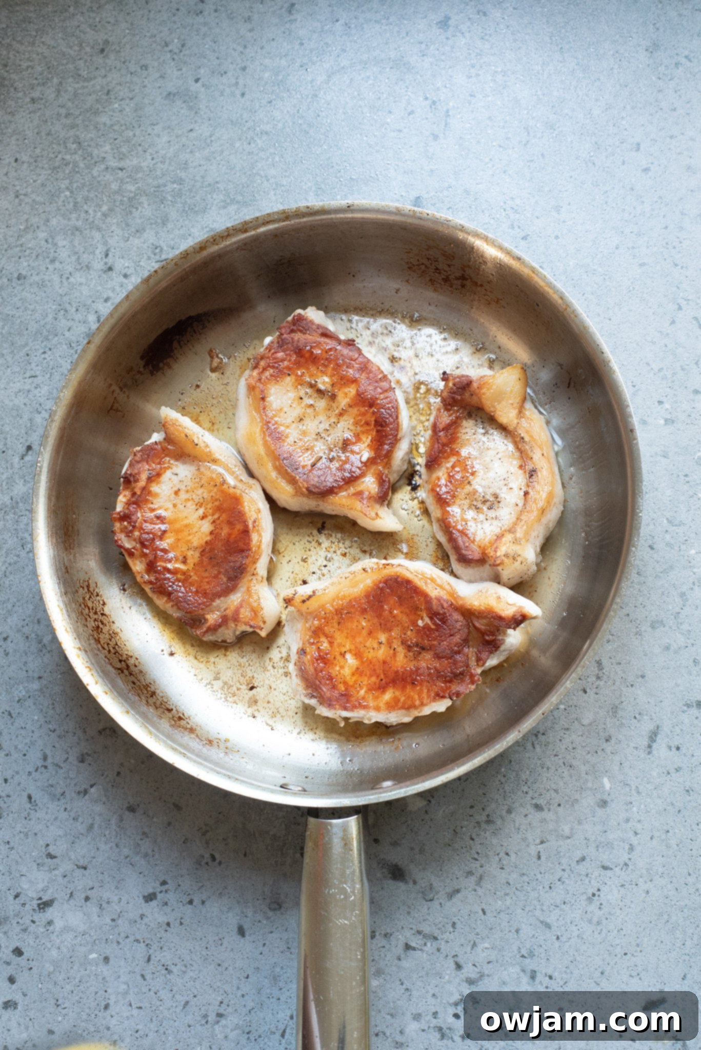 Sweet and Savory Pineapple Pork Chops 6 Seared pork chops pushed to one side of the skillet, making room for other ingredients.