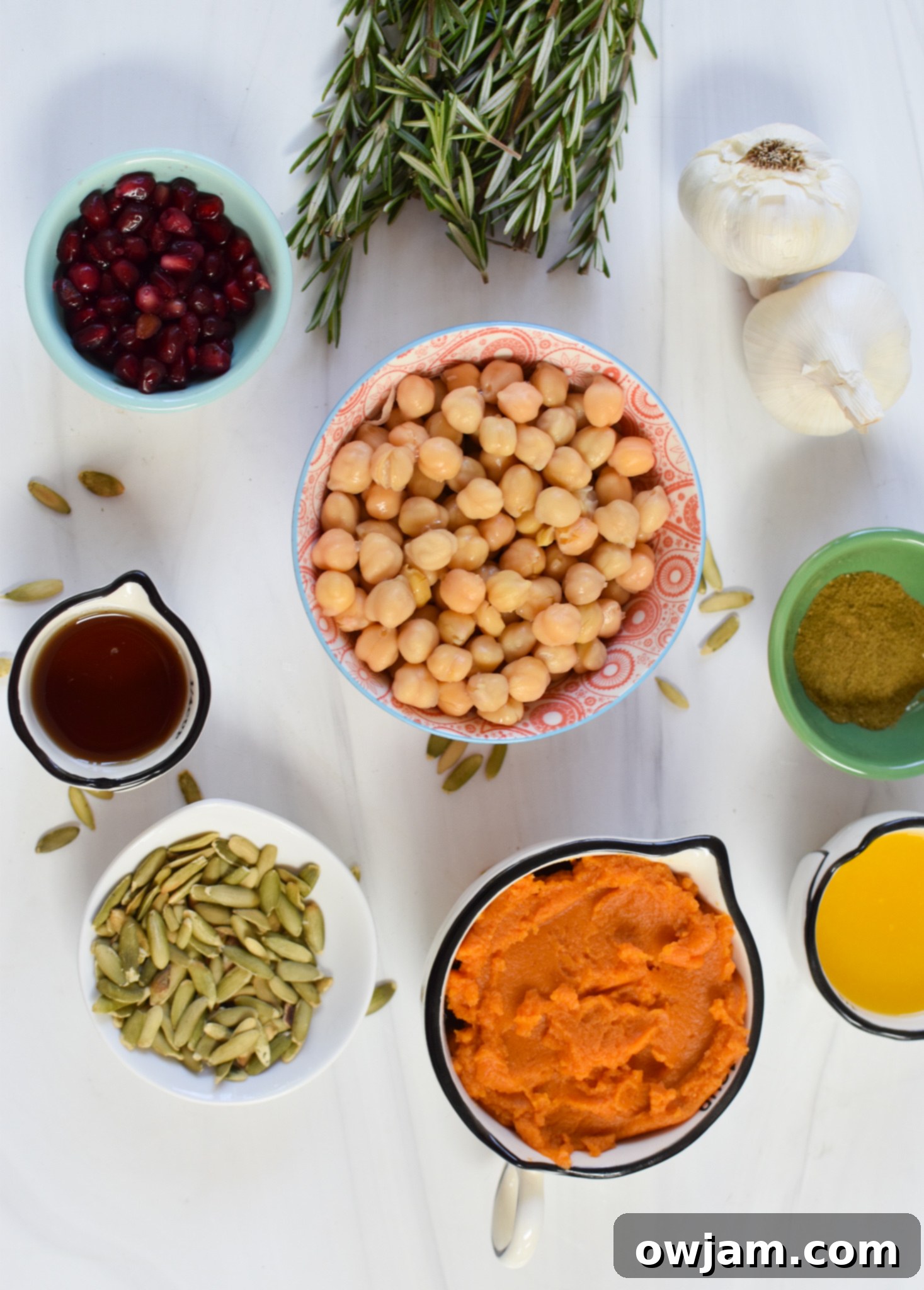 Velvet Pumpkin Dip 3 Various ingredients for Creamy Pumpkin Hummus including chickpeas, pumpkin puree, tahini, olive oil, and spices laid out on a cutting board.