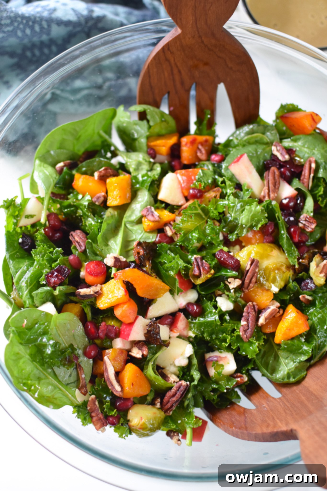 Autumn Bounty Bowl 4 A vibrant Fall Harvest Salad generously mixed in a clear glass bowl, showcasing the colorful array of ingredients.